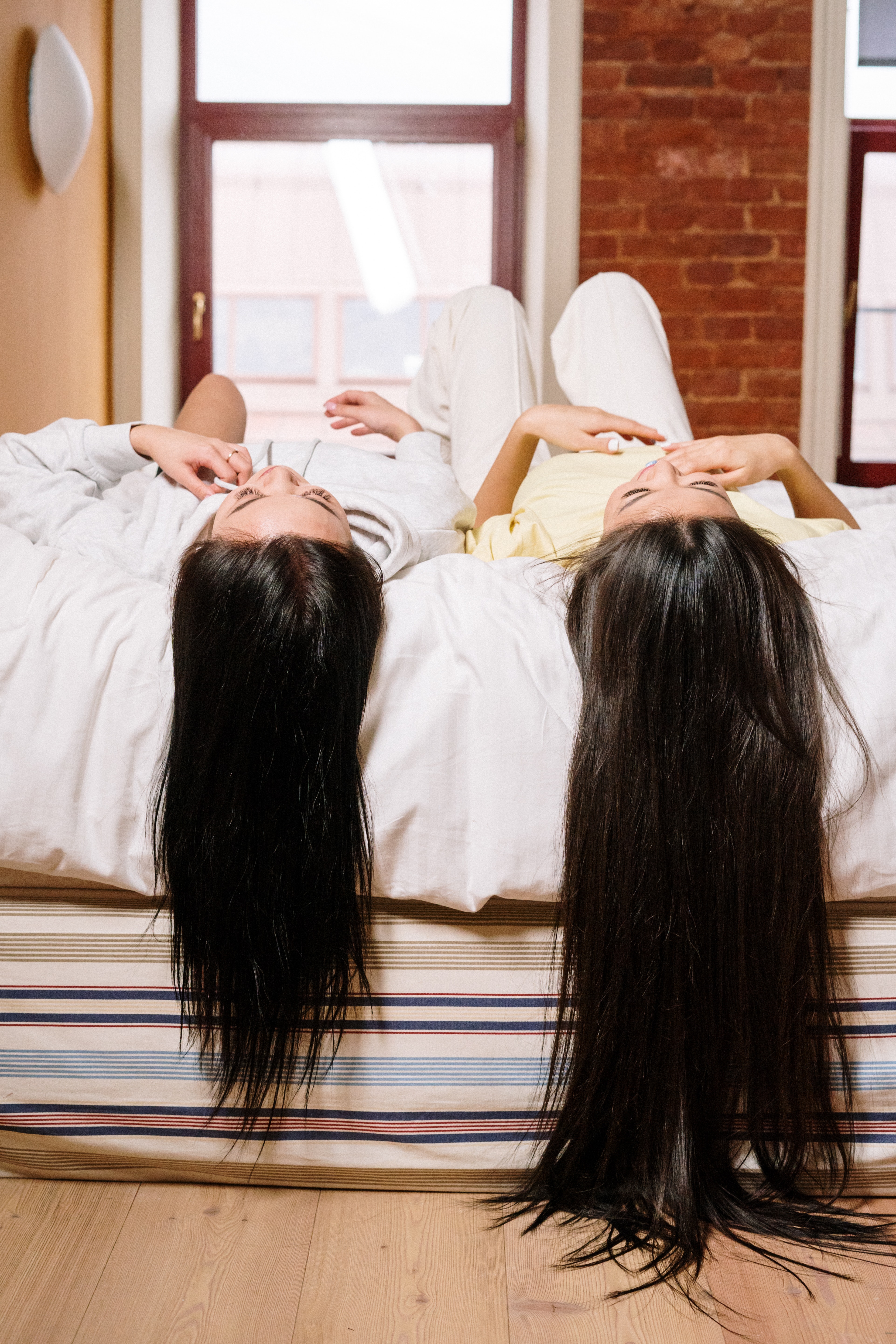 La femme allongée sur un lit avec leurs cheveux qui pendent du lit | Source : Pexels