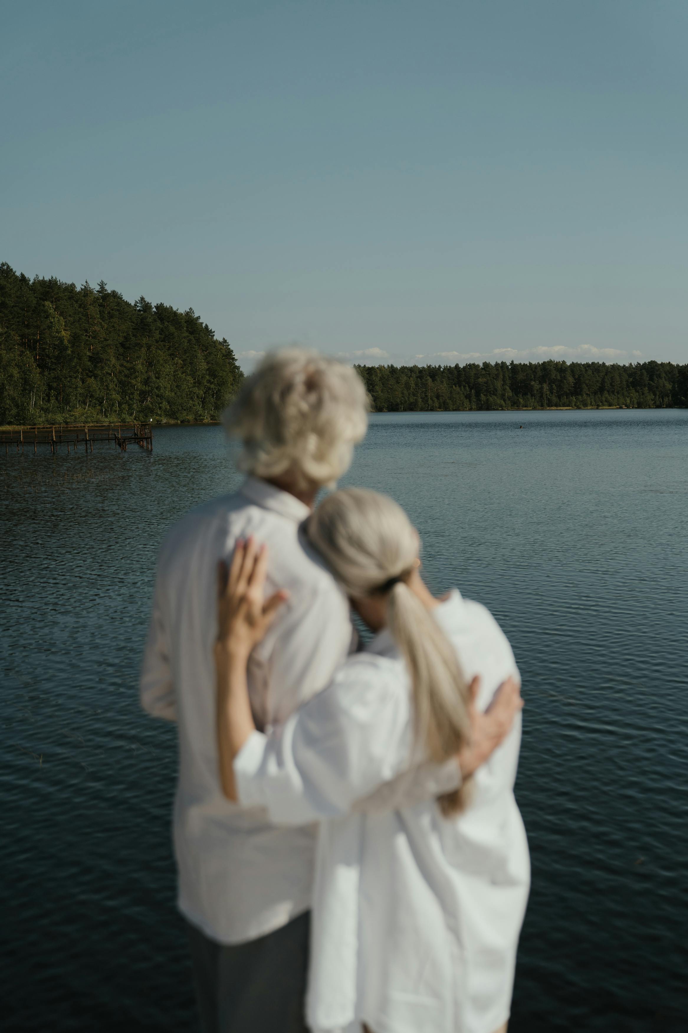Un couple plus âgé s'embrassant face à un lac | Source : Pexels