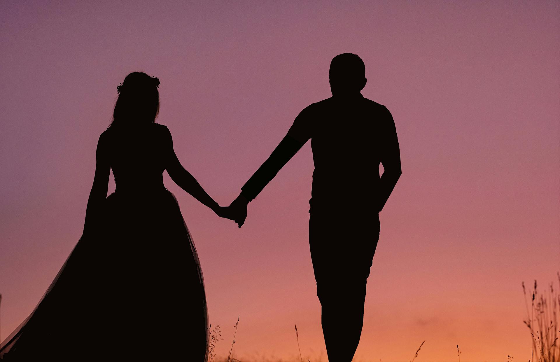 Silhouette d'un couple se tenant par la main | Source : Pexels