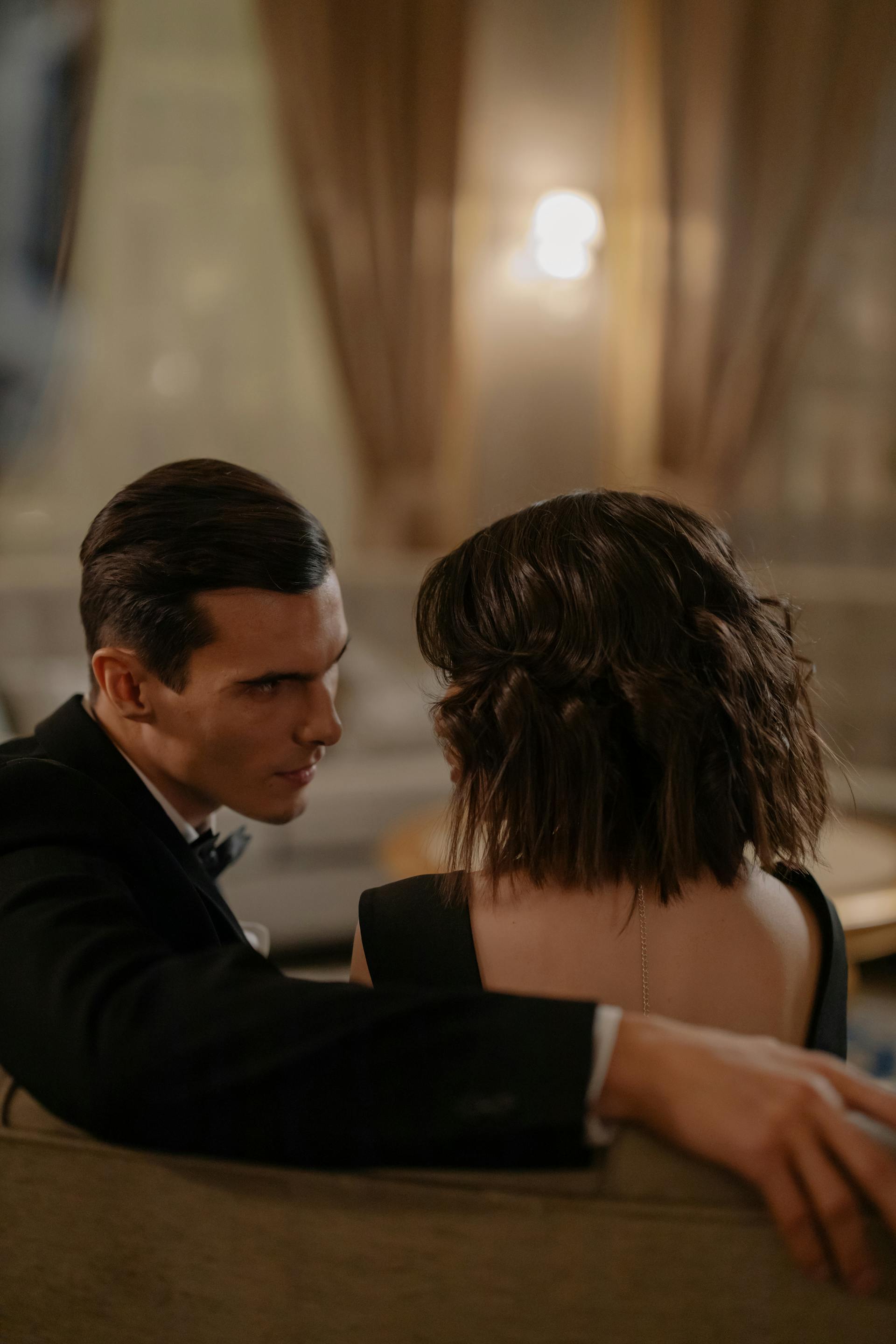 Un jeune couple assis sur le canapé et se regardant fixement | Source : Pexels