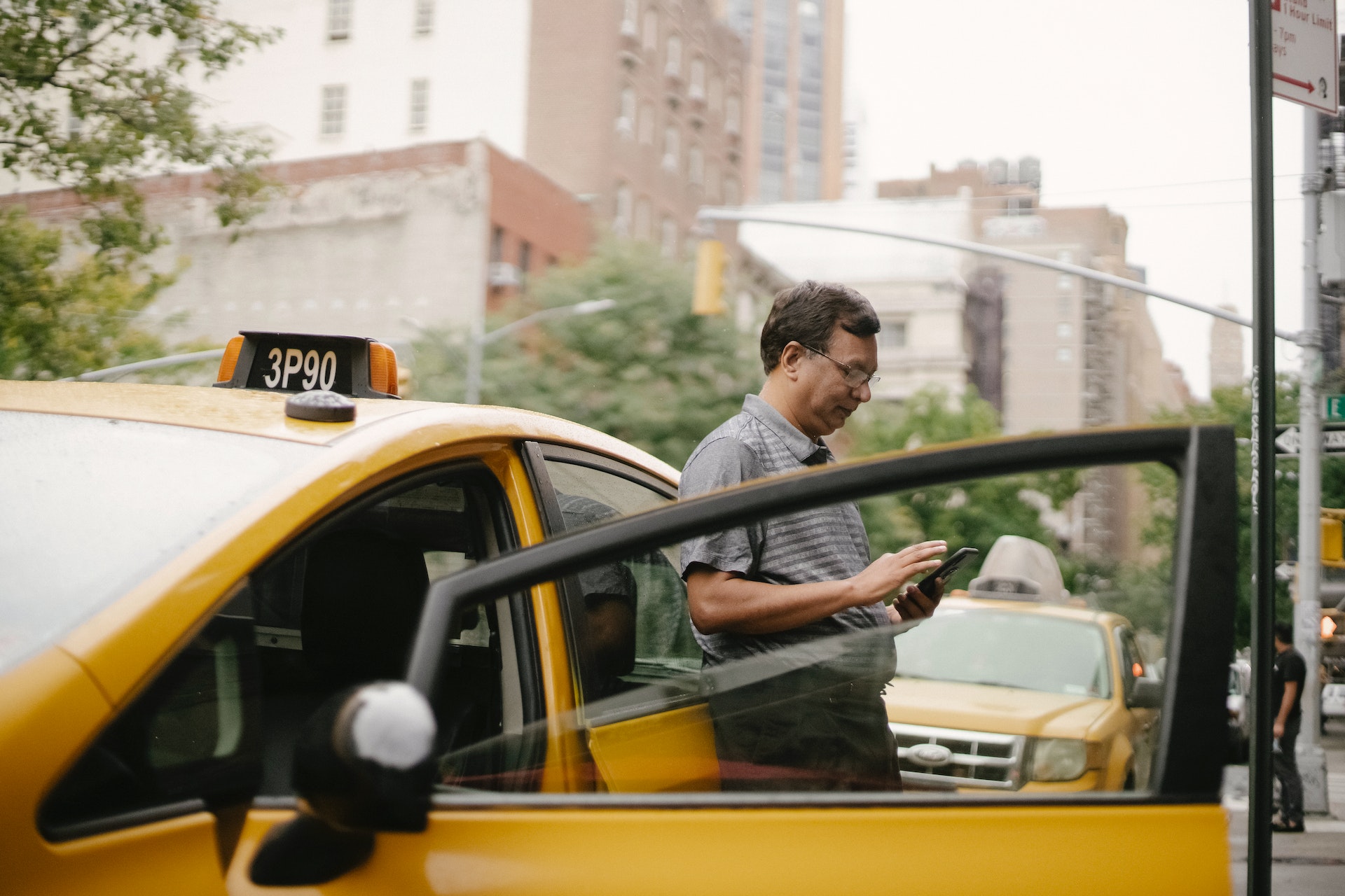 Un homme adossé à un taxi | Source : Pexels