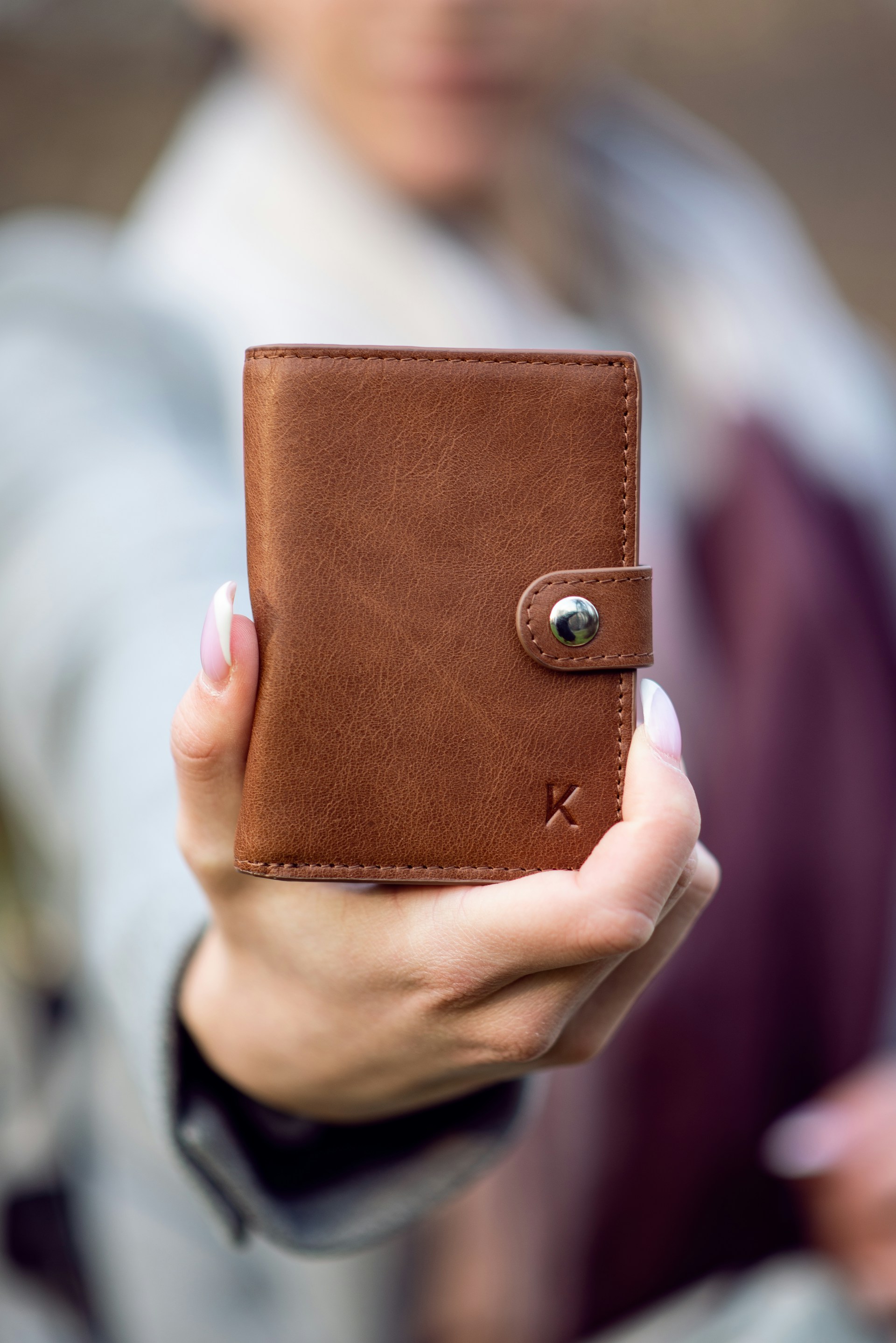 Une femme tenant un portefeuille en cuir marron | Source : Unsplash
