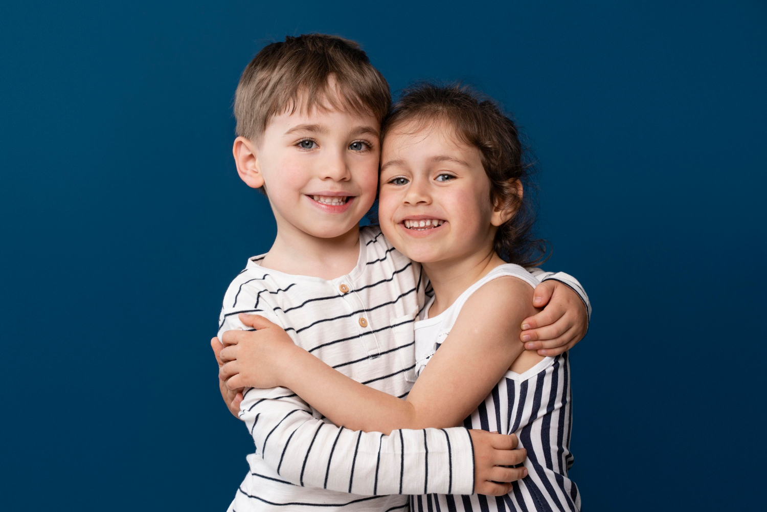 Deux enfants joyeux qui s'embrassent | Source : Freepik