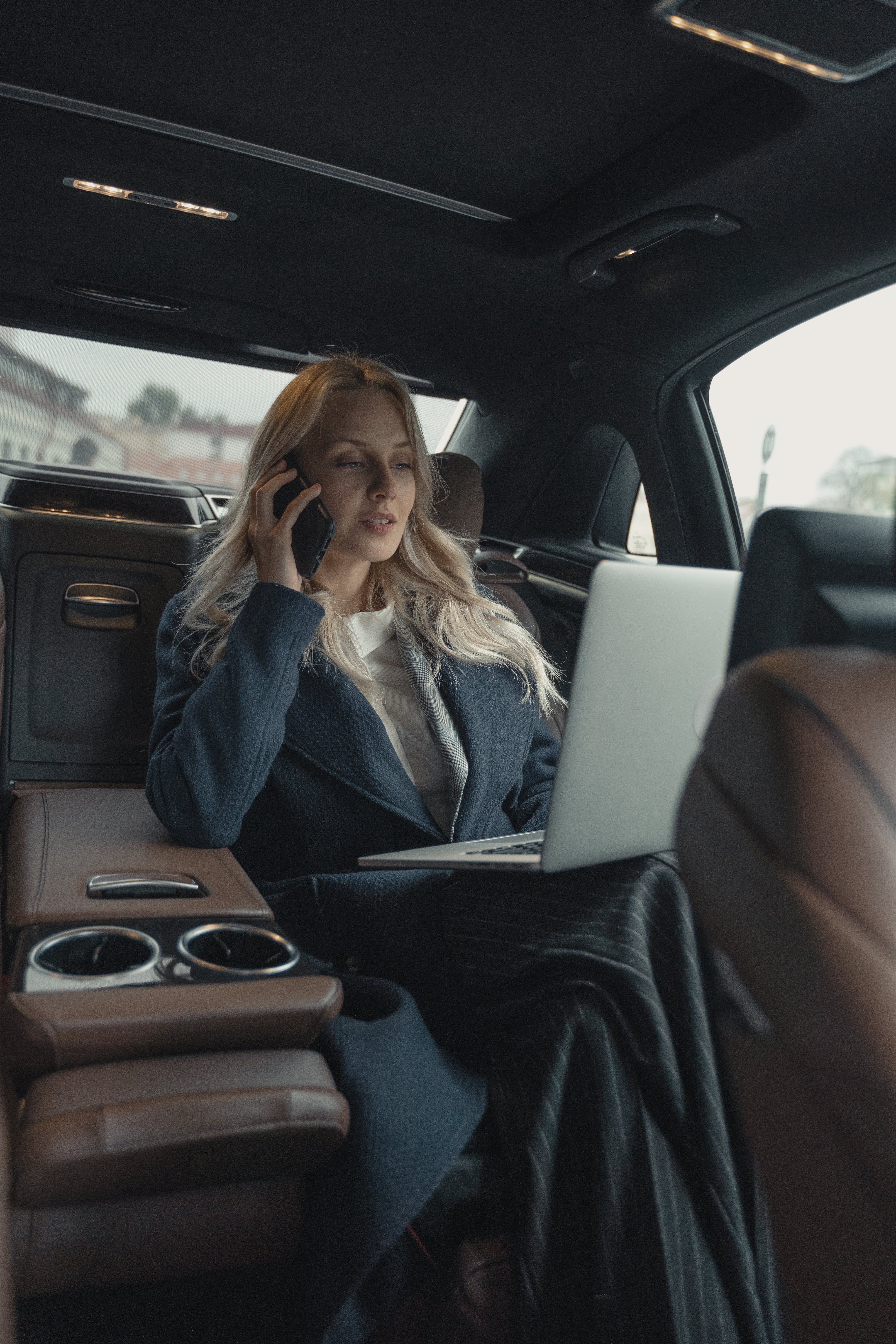 Una mujer de negocios sentada en un lujoso Automóvil. | Fuente: Pexels
