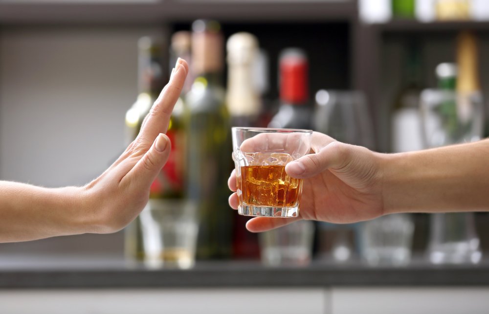 Une personne qui refuse un verre d'alcool. | Shutterstock