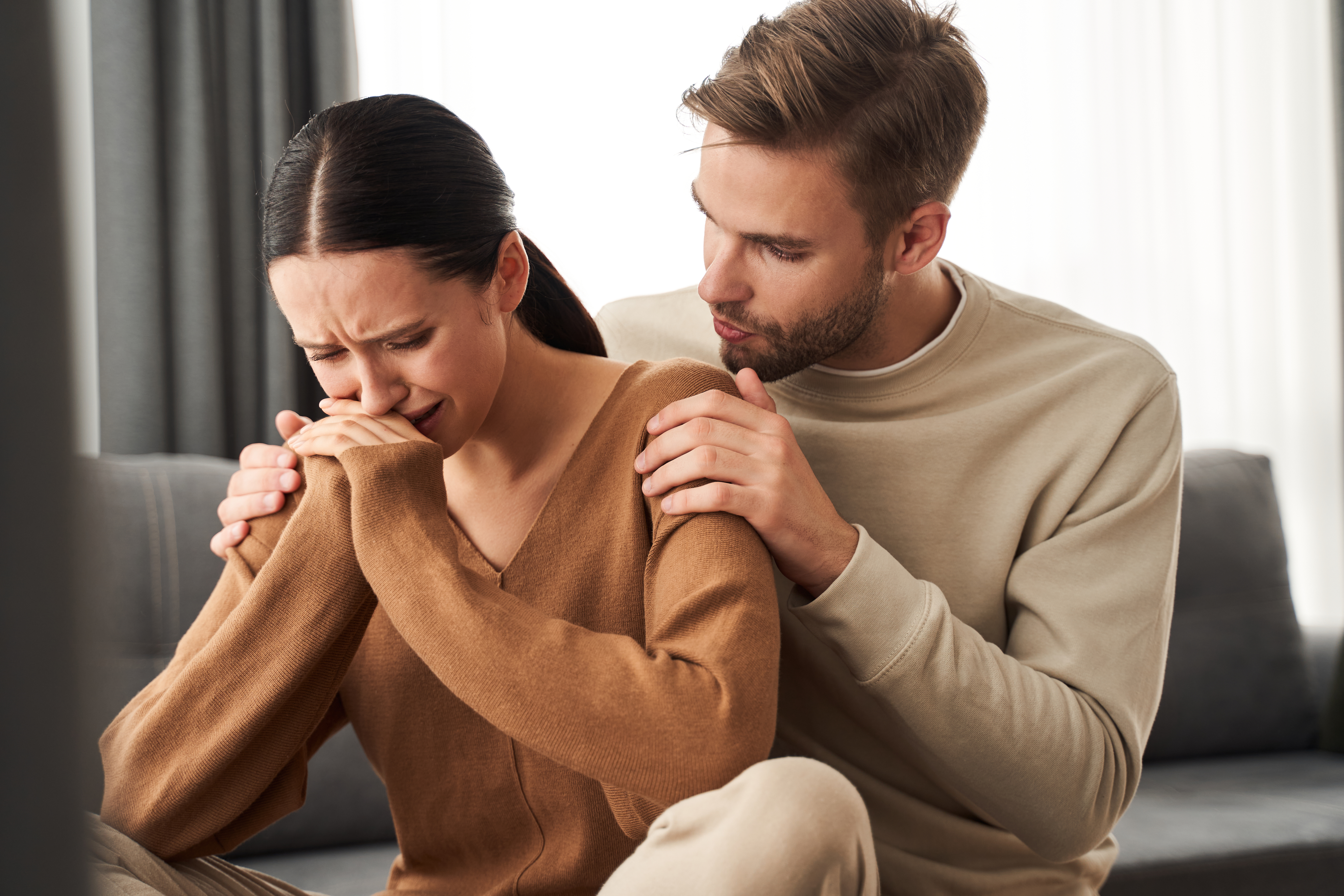 Un homme calme une femme en pleurs | Source : Shutterstock