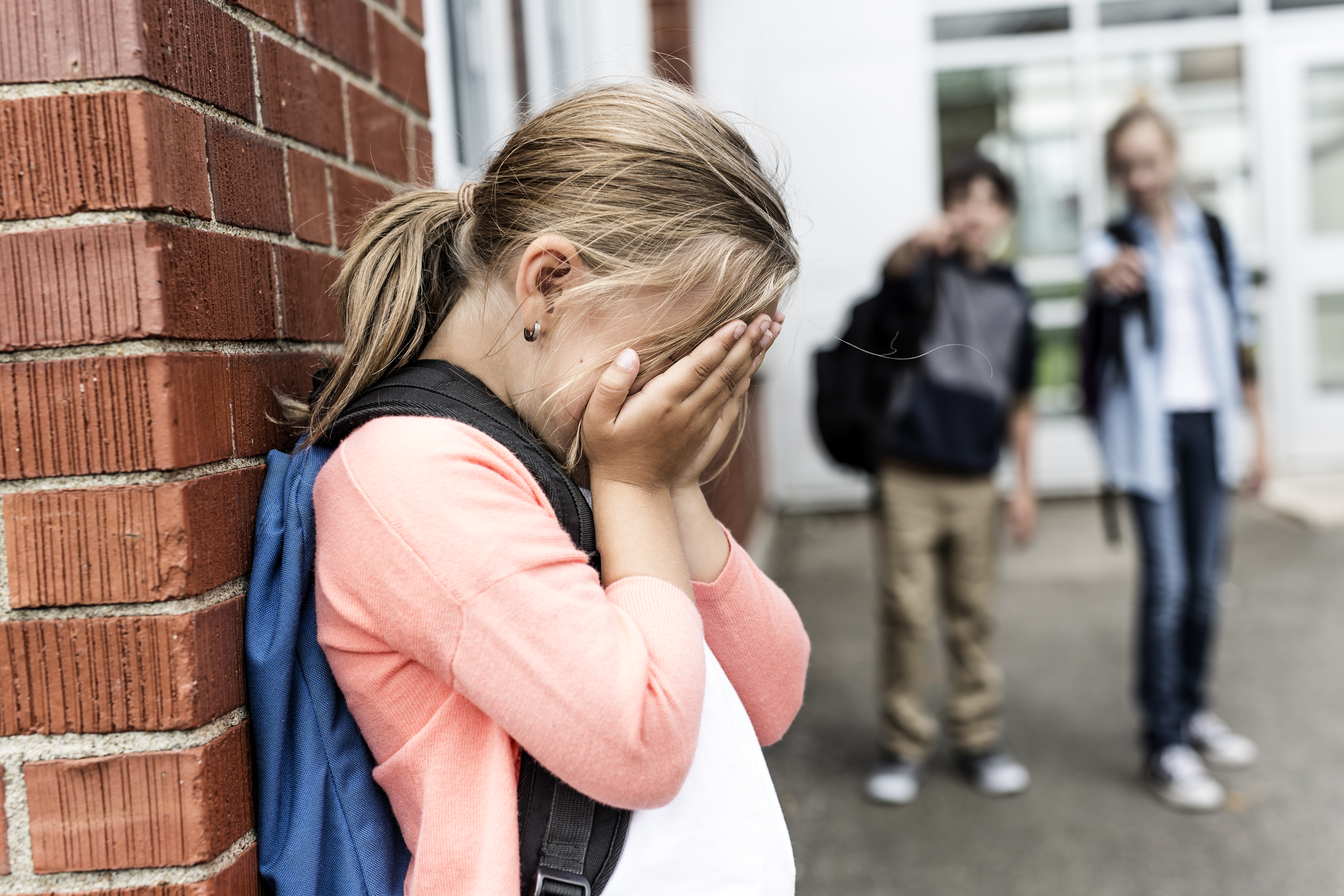 Une fille qui pleure dans le couloir de l'école | Source : Shutterstock