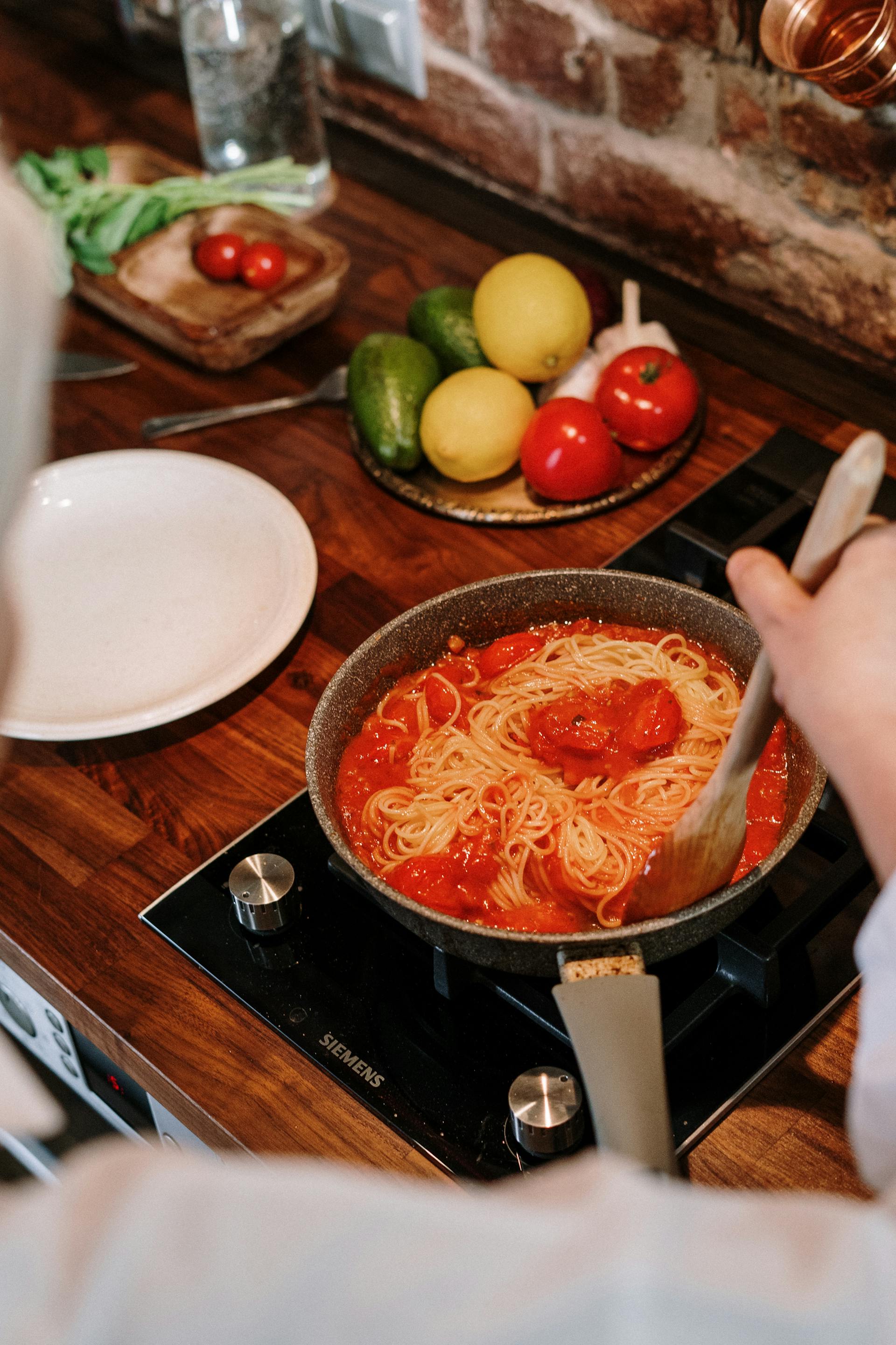 Gros plan sur une femme en train de remuer une casserole dans la cuisine | Source : Pexels