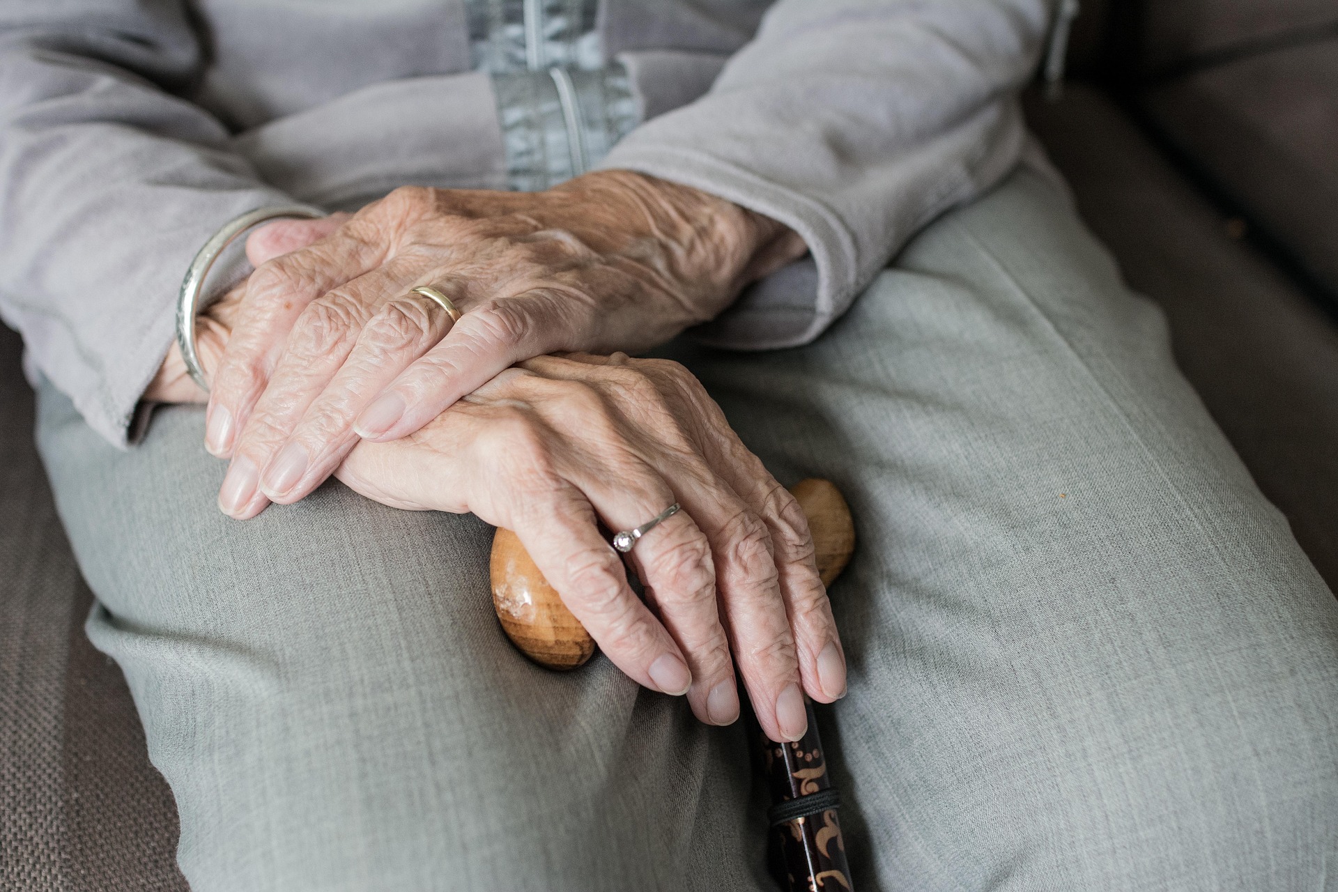 Photo recadrée d'une femme âgée assise tenant sa canne | Source : Pixabay