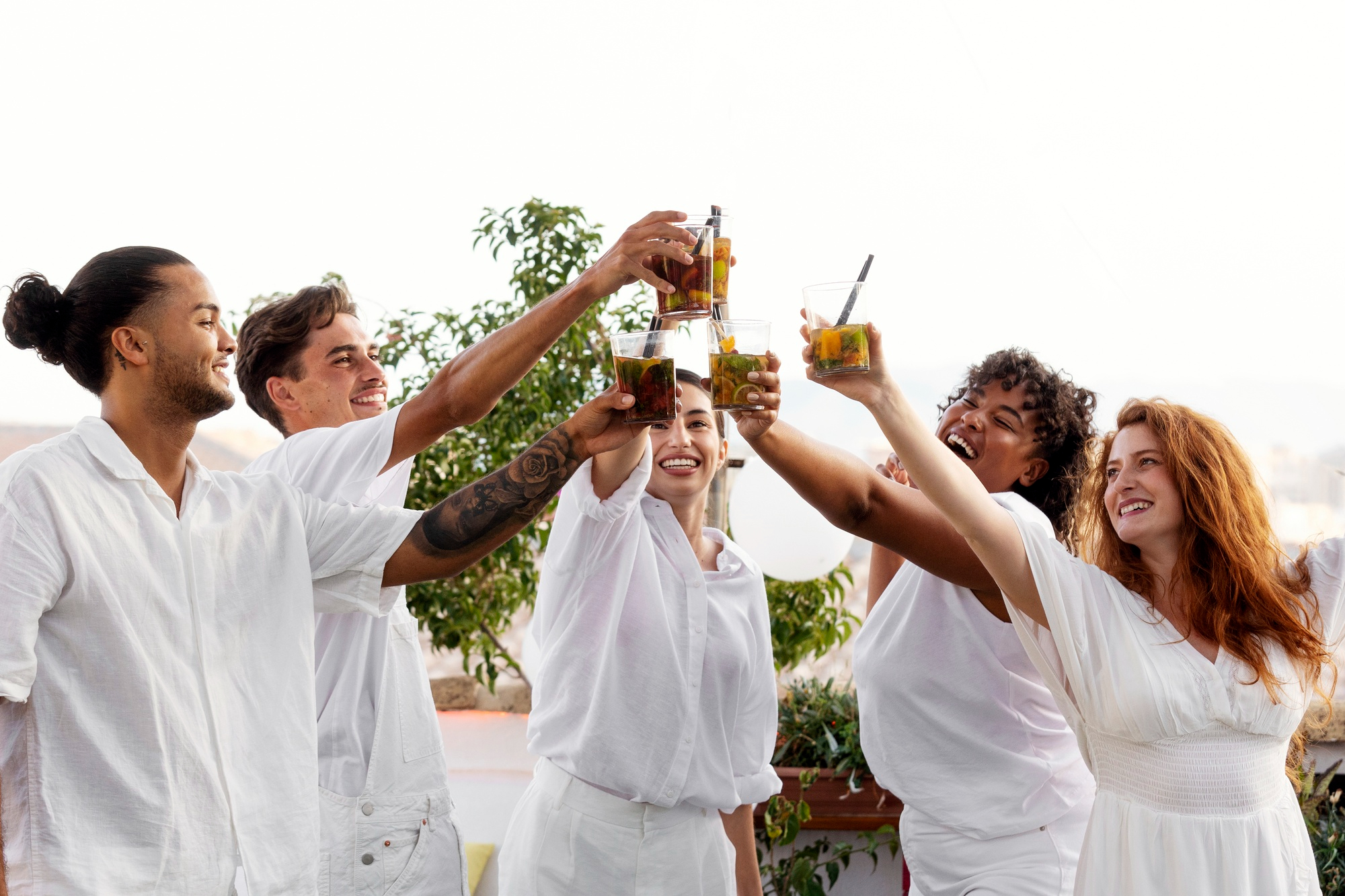 Des gens portent un toast lors d'une fête à thème blanche | Source : Freepik