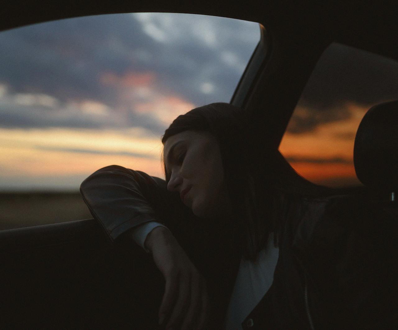 Une femme déprimée s'appuyant sur la vitre d'une voiture | Source : Pexels