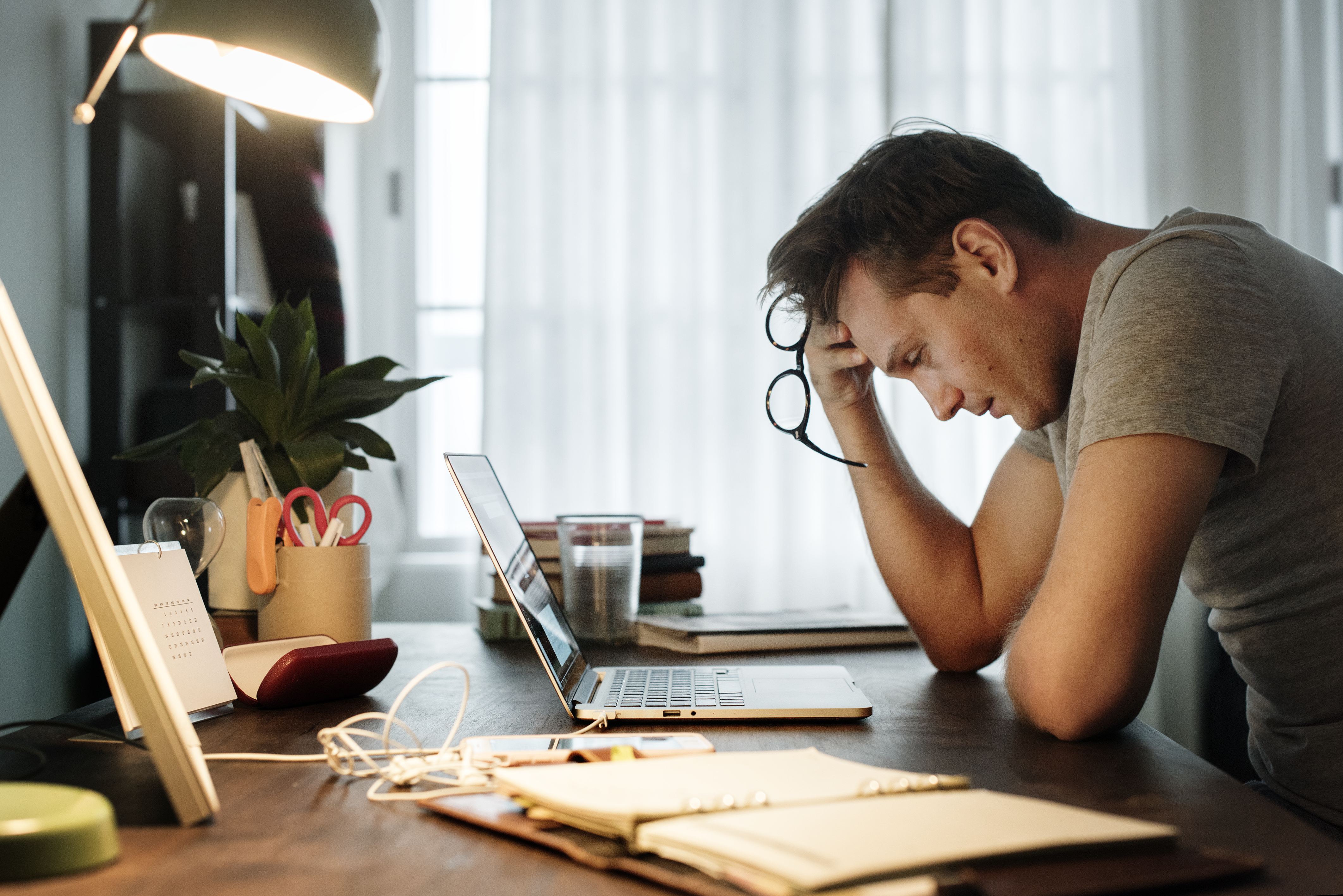 Homme stressé alors qu'il travaille sur son ordinateur portable | Source : Getty Images