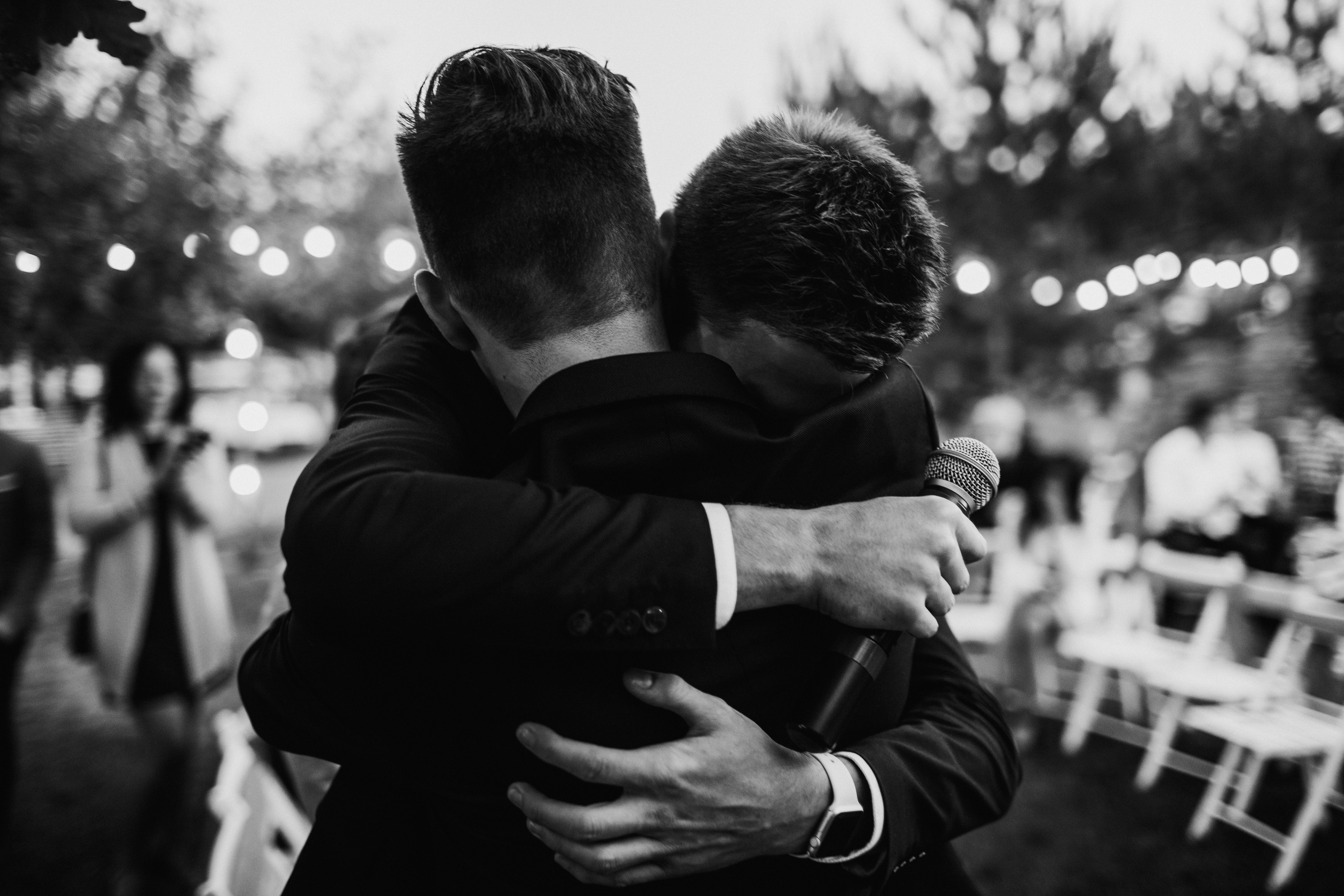 Un marié en train de serrer son frère dans ses bras | Source : Shutterstock
