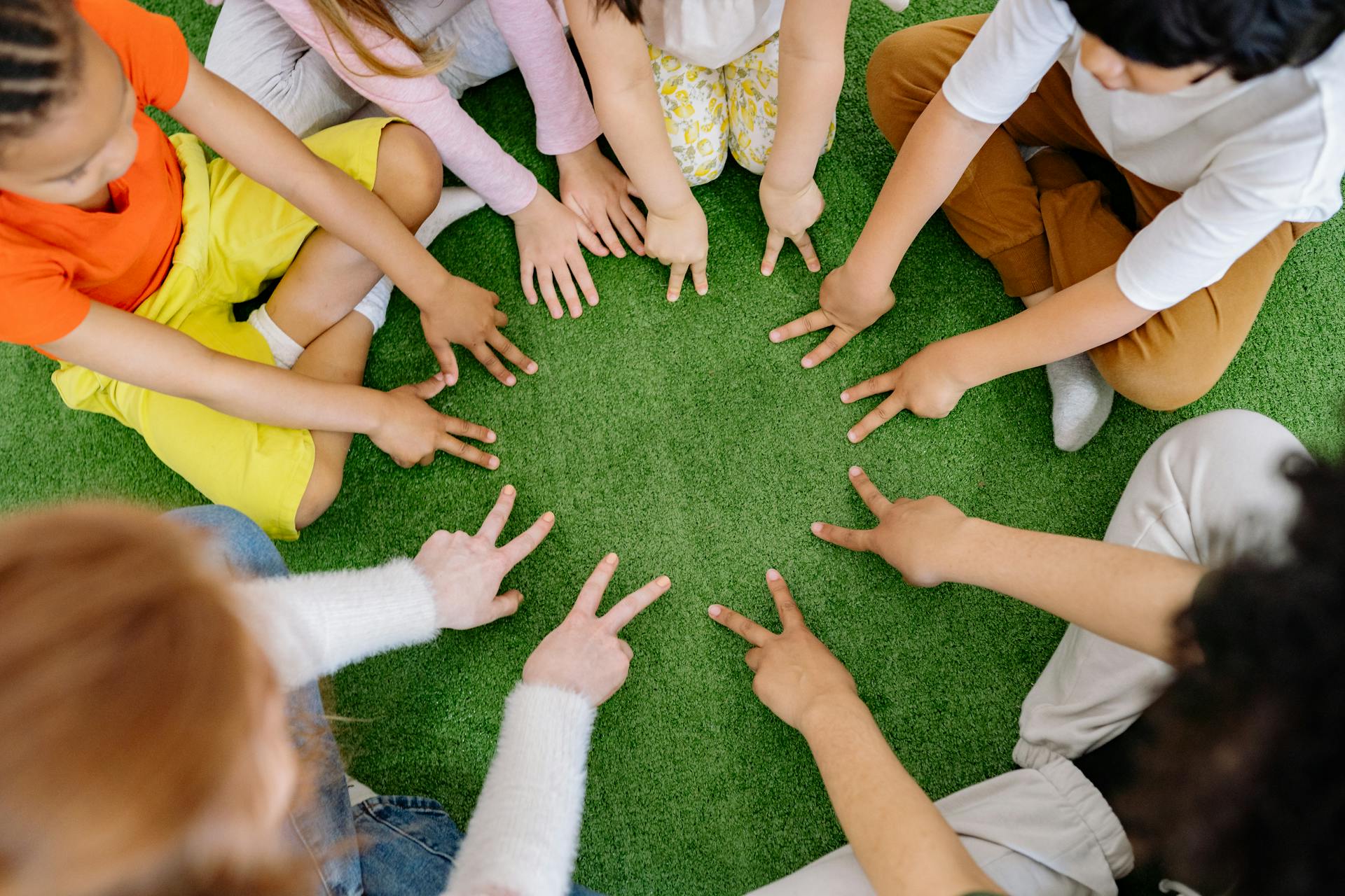 Enfants assis sur l'herbe | Source : Pexels
