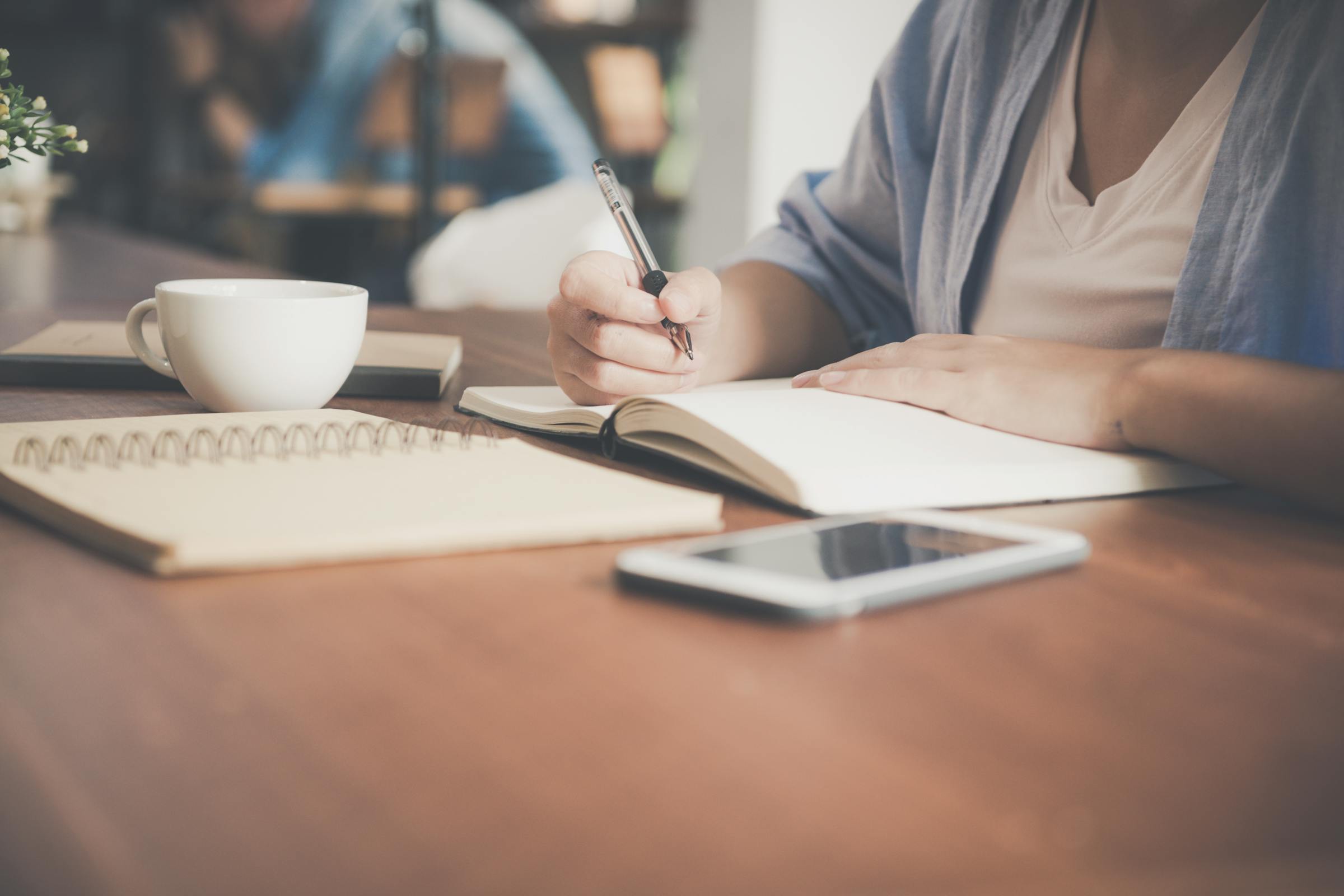 Une jeune femme qui écrit sur un cahier | Source : Pexels