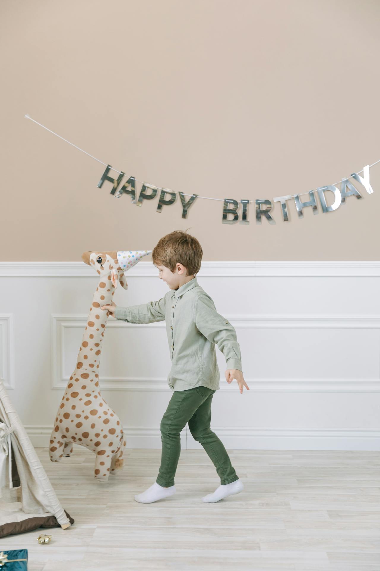 Un petit garçon ravi tenant une peluche de girafe | Source : Pexels