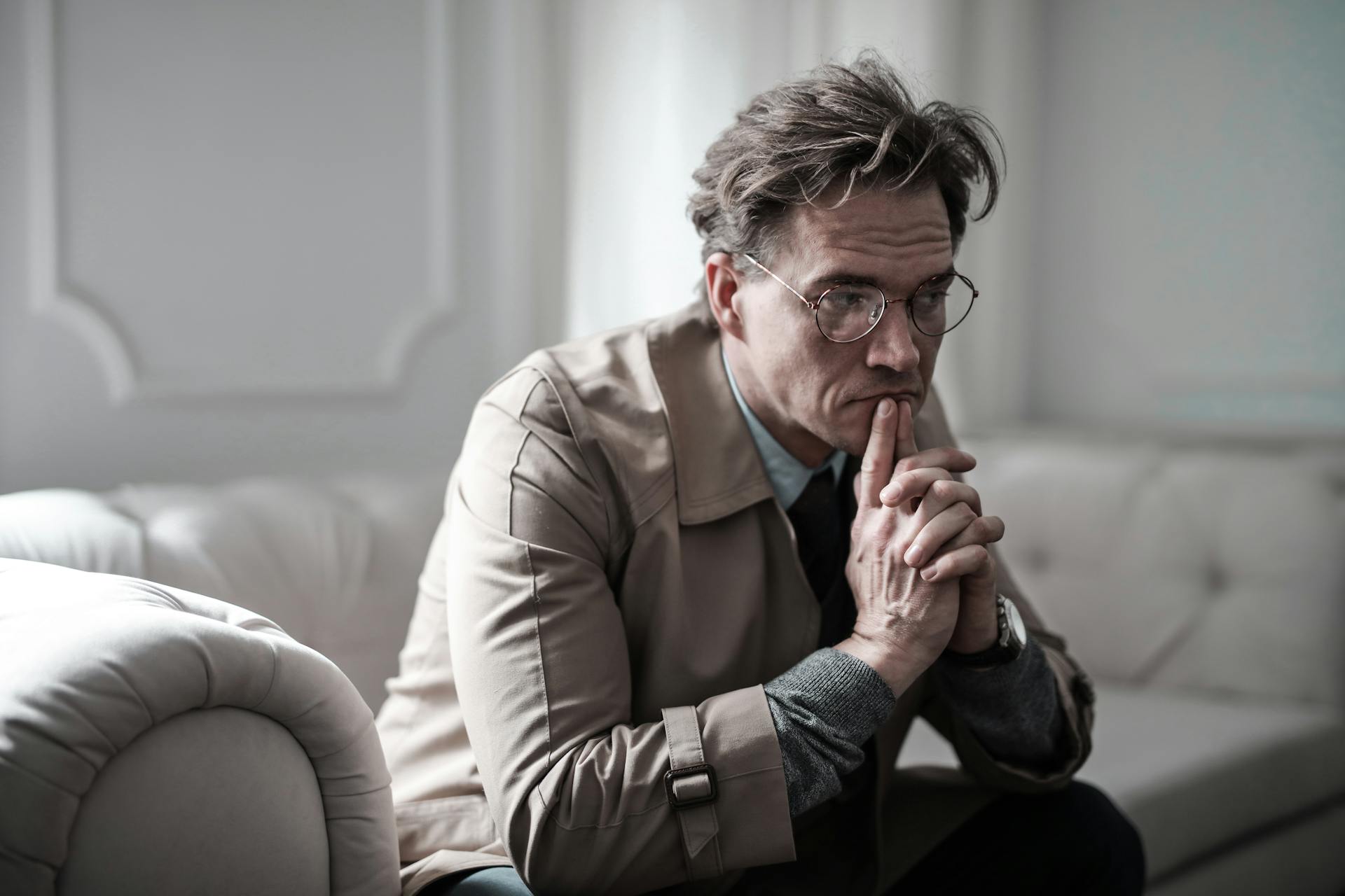 Un homme pensif assis sur un canapé | Source : Pexels