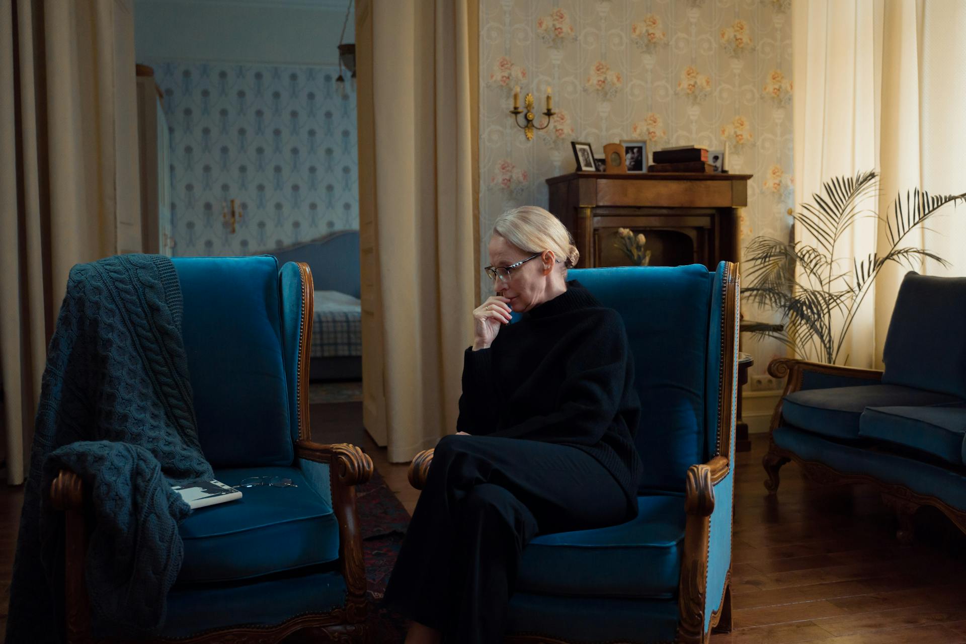 Une femme âgée assise sur un canapé bleu | Source : Pexels