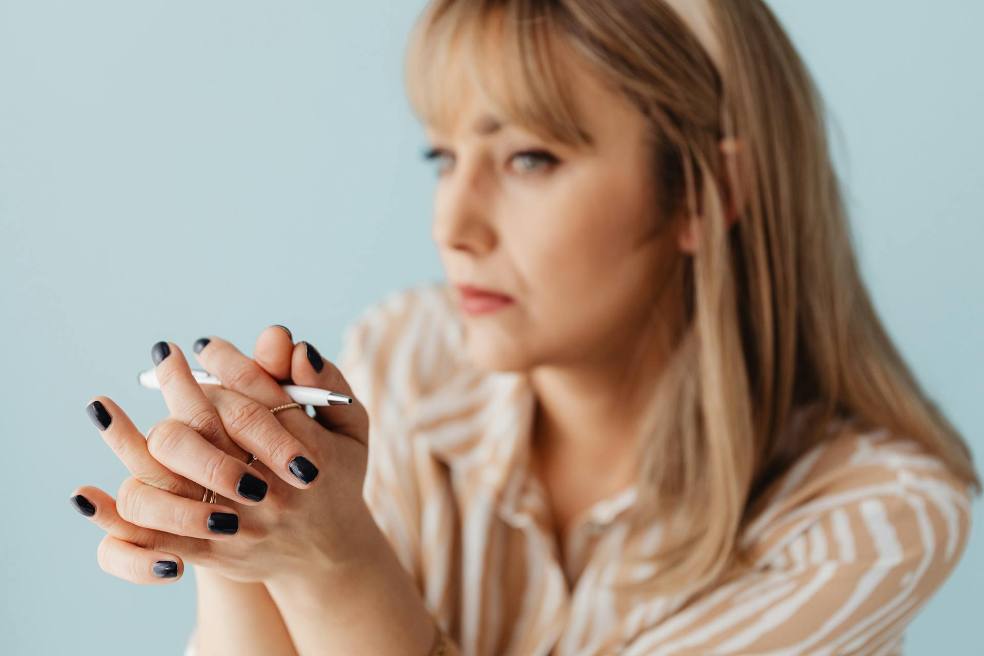 Une femme tenant un stylo blanc | Source : Pexels