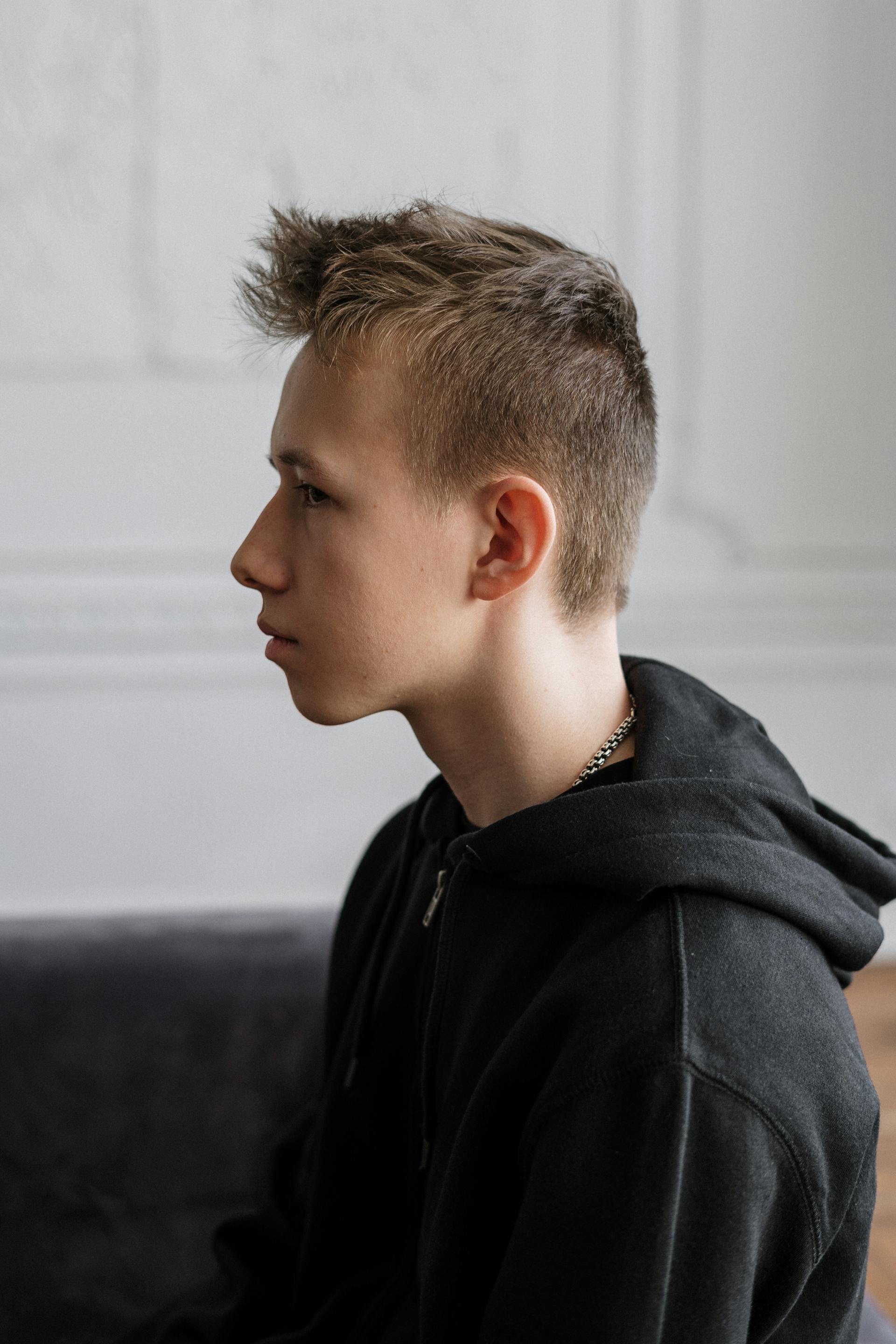 Un adolescent pensif sur un canapé | Source : Pexels
