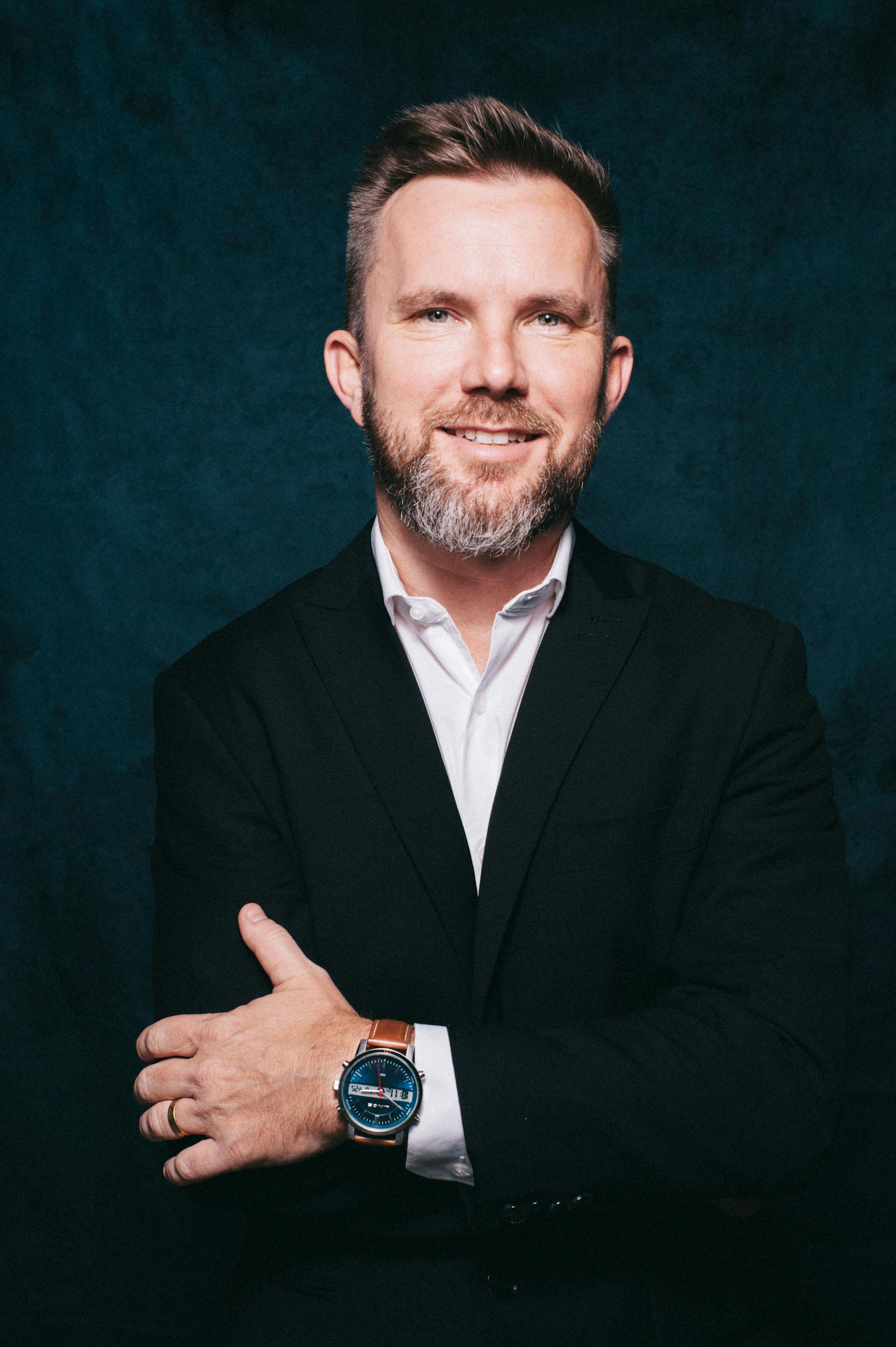 Un homme d'âge moyen souriant en costume | Source : Pexels