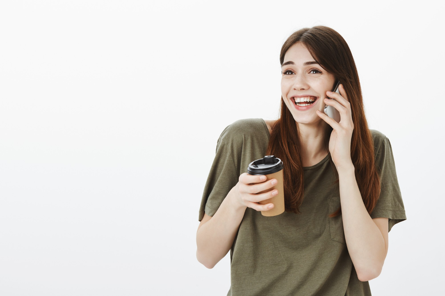 Une femme tenant une tasse de café et riant tout en parlant au téléphone | Source : Freepik