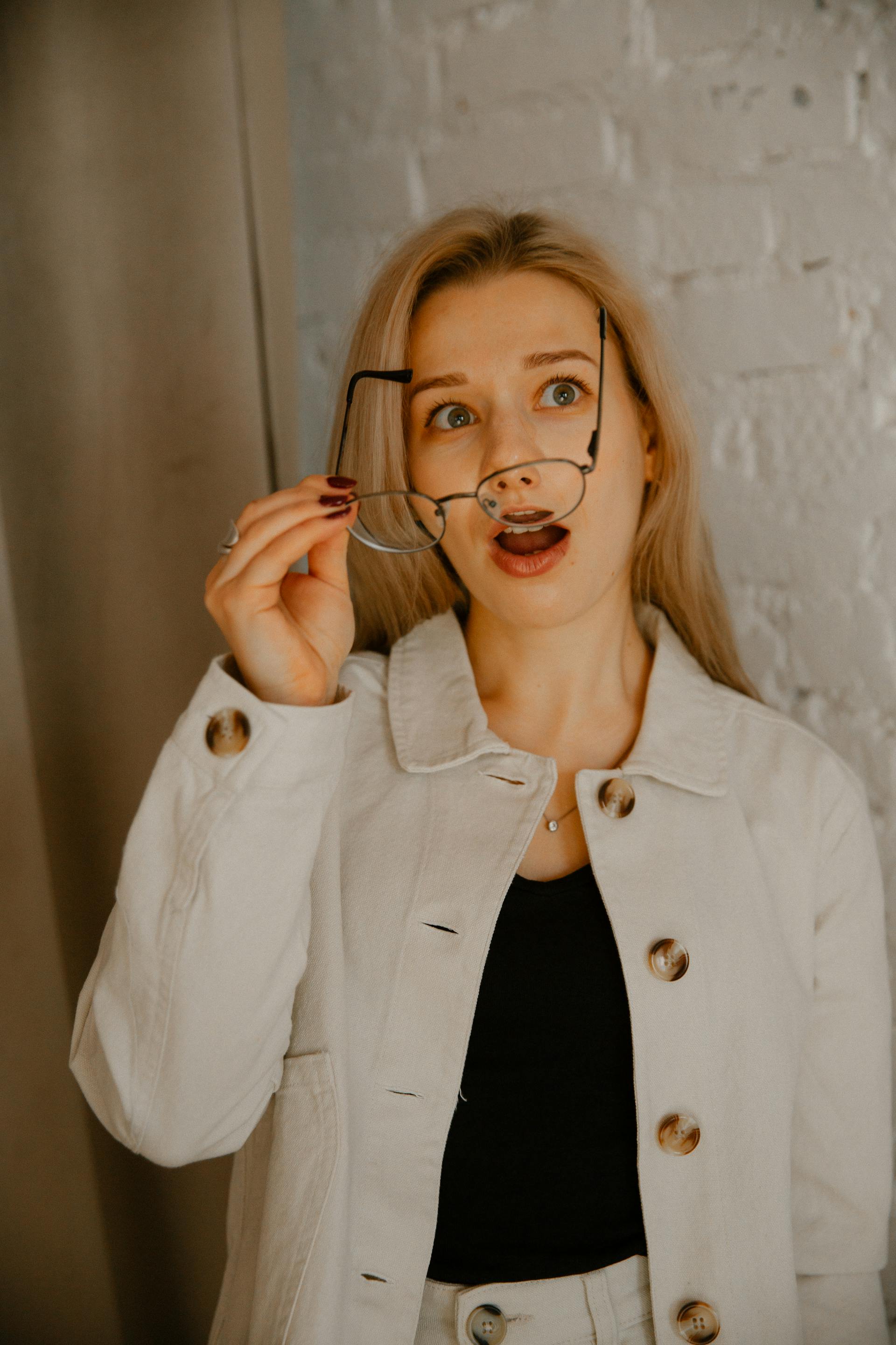 Une femme surprise en train d'enlever ses lunettes | Source : Pexels