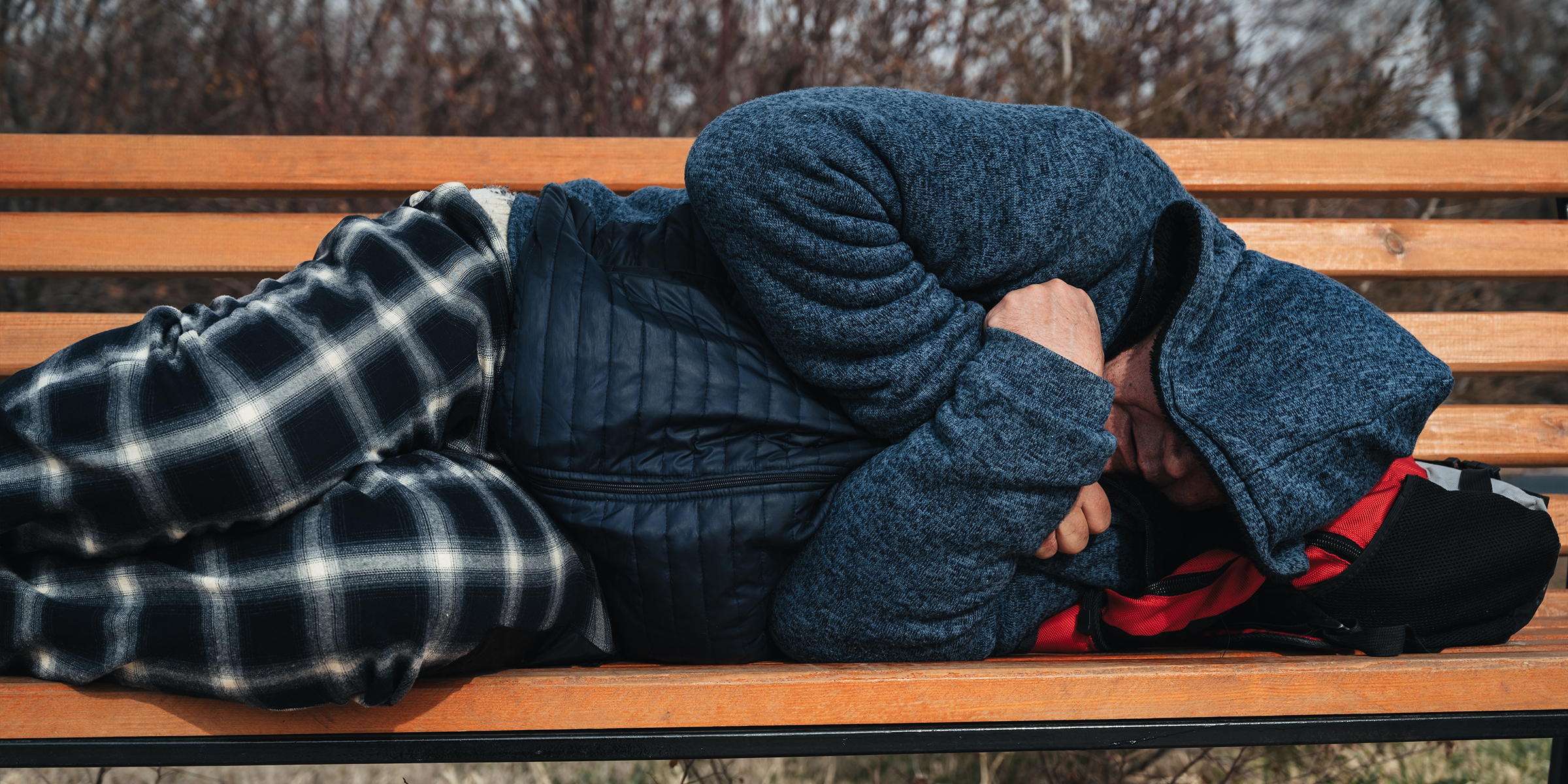 Un homme qui dort sur un banc | Source : Shutterstock