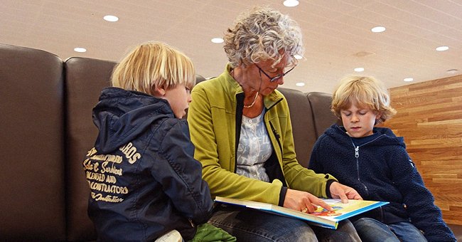 Une grand-mère lisant un livre à ses petits-enfants. | Photo : Shutterstock