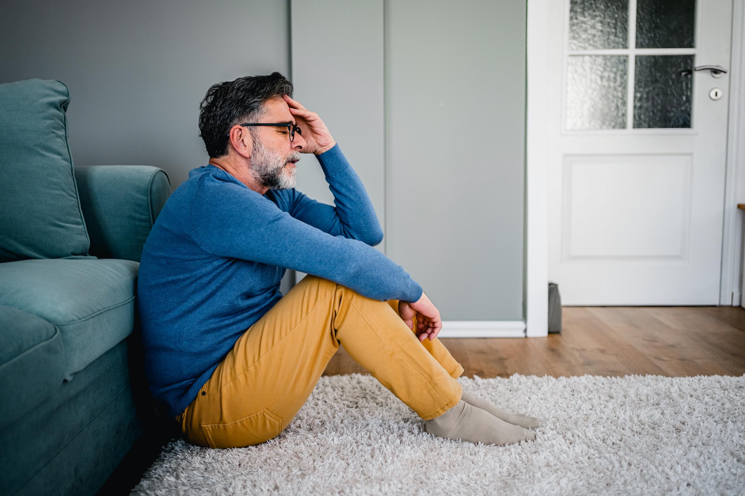 Homme souffrant d'un mal de tête, se tenant la tête dans l'inconfort | Source : Getty Images
