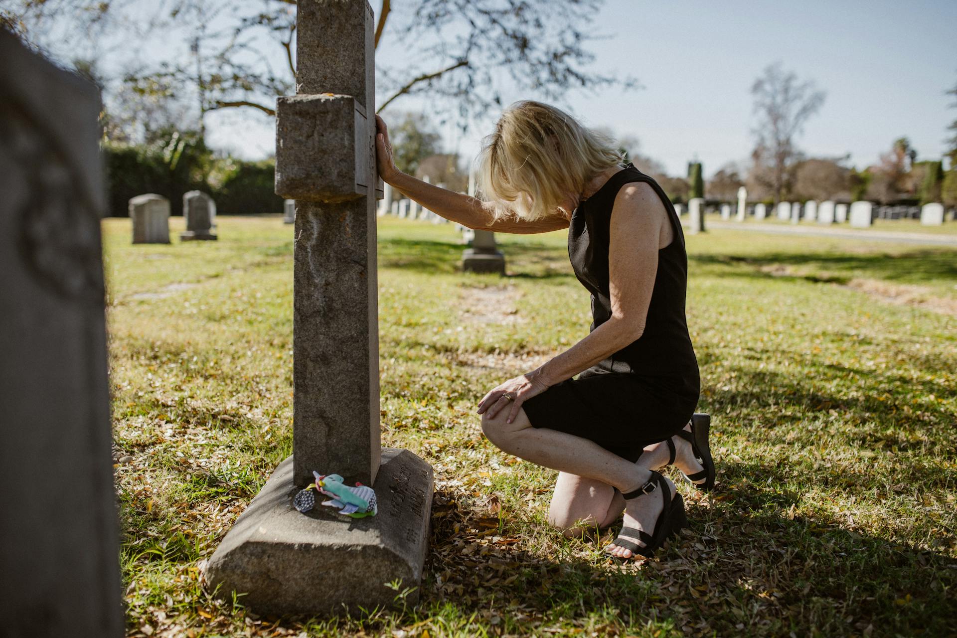 Une femme assise près d'une tombe | Source : Pexels