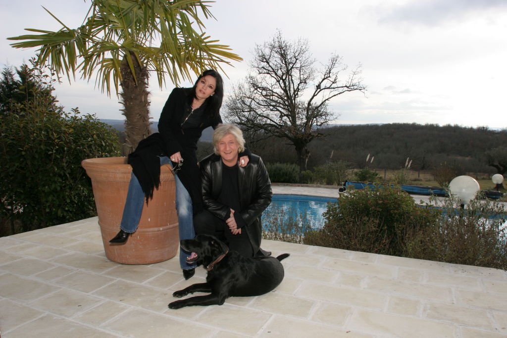 Patrick SEBASTIEN et son épouse Françoise posant avec leur chien labrador Tyson sur la terrasse de leur maison à MARTEL, près de Brive -la -Gaillarde. | Photo : Getty Images