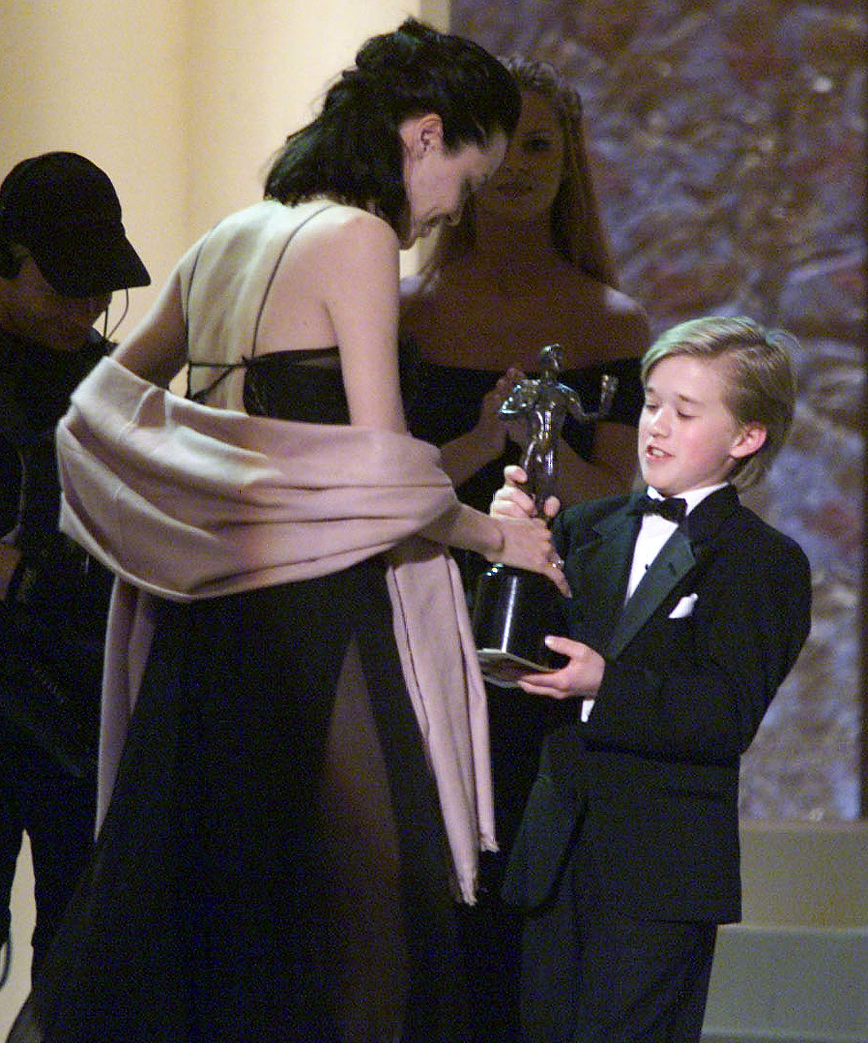 Angelina Jolie accepte son prix des mains de Haley Osment lors de la sixième édition des Screen Actors Guild Awards (SAG) le 12 mars 2000 à Los Angeles. | Source : Getty Images