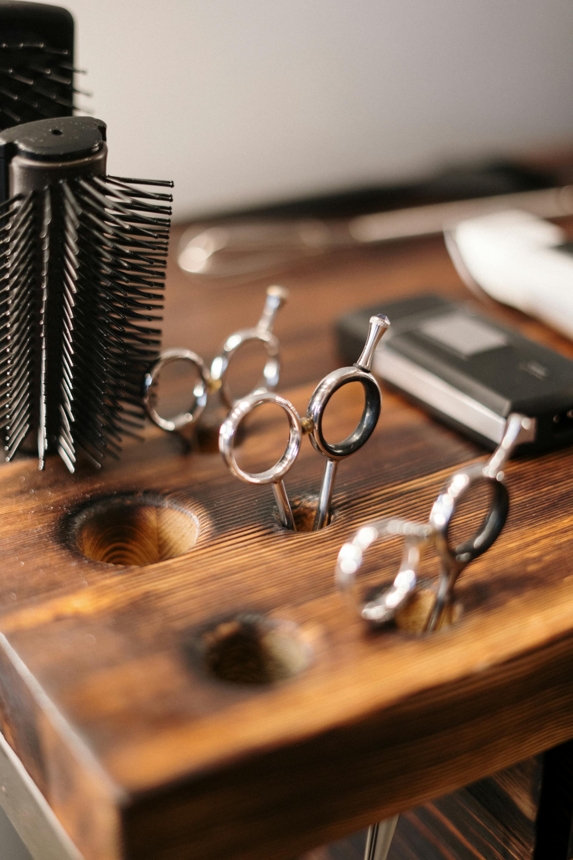 Gros plan sur des ciseaux et des brosses dans un salon de coiffure | Source : Pexels