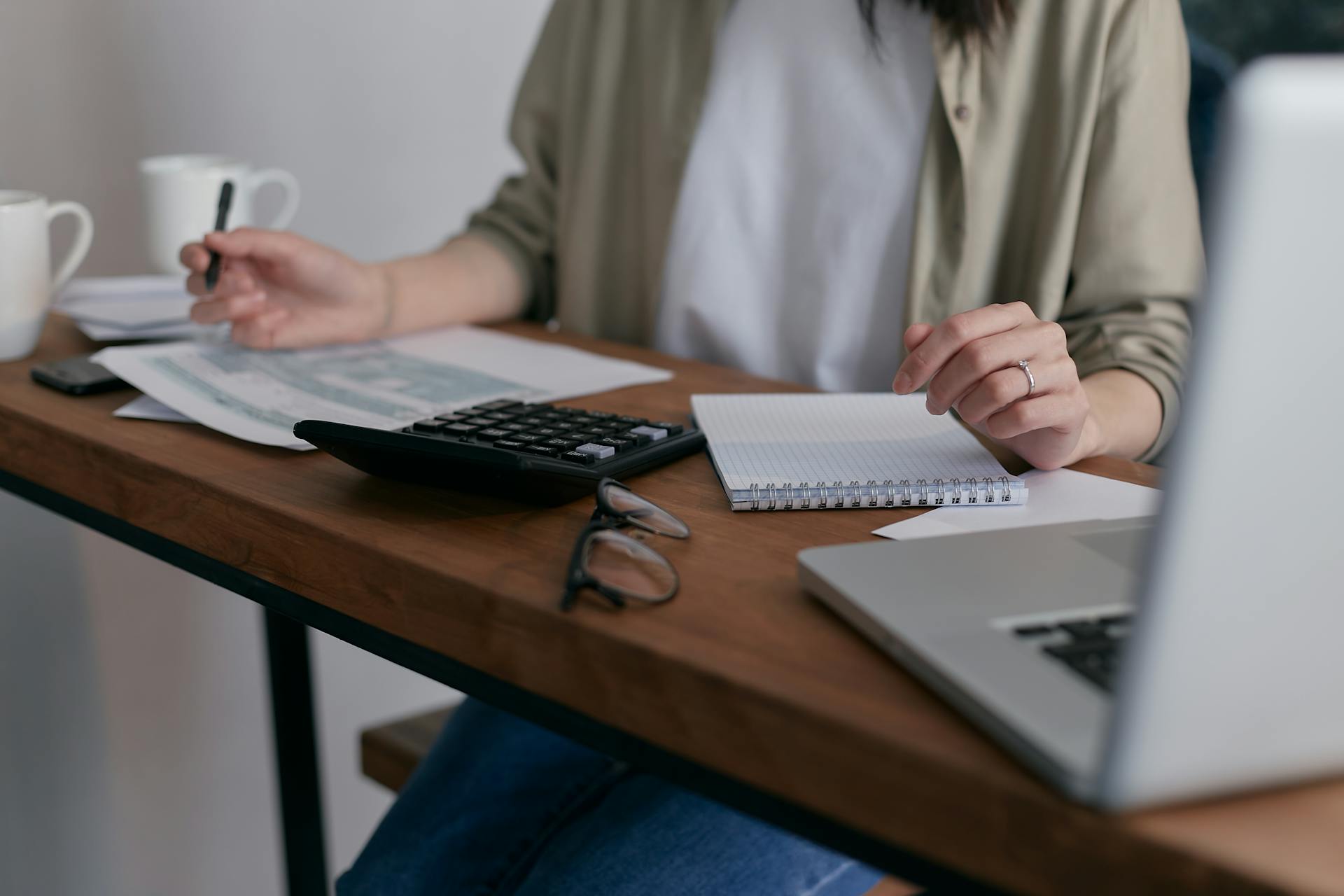 Une femme travaillant avec un bloc-notes et une calculatrice | Source : Pexels