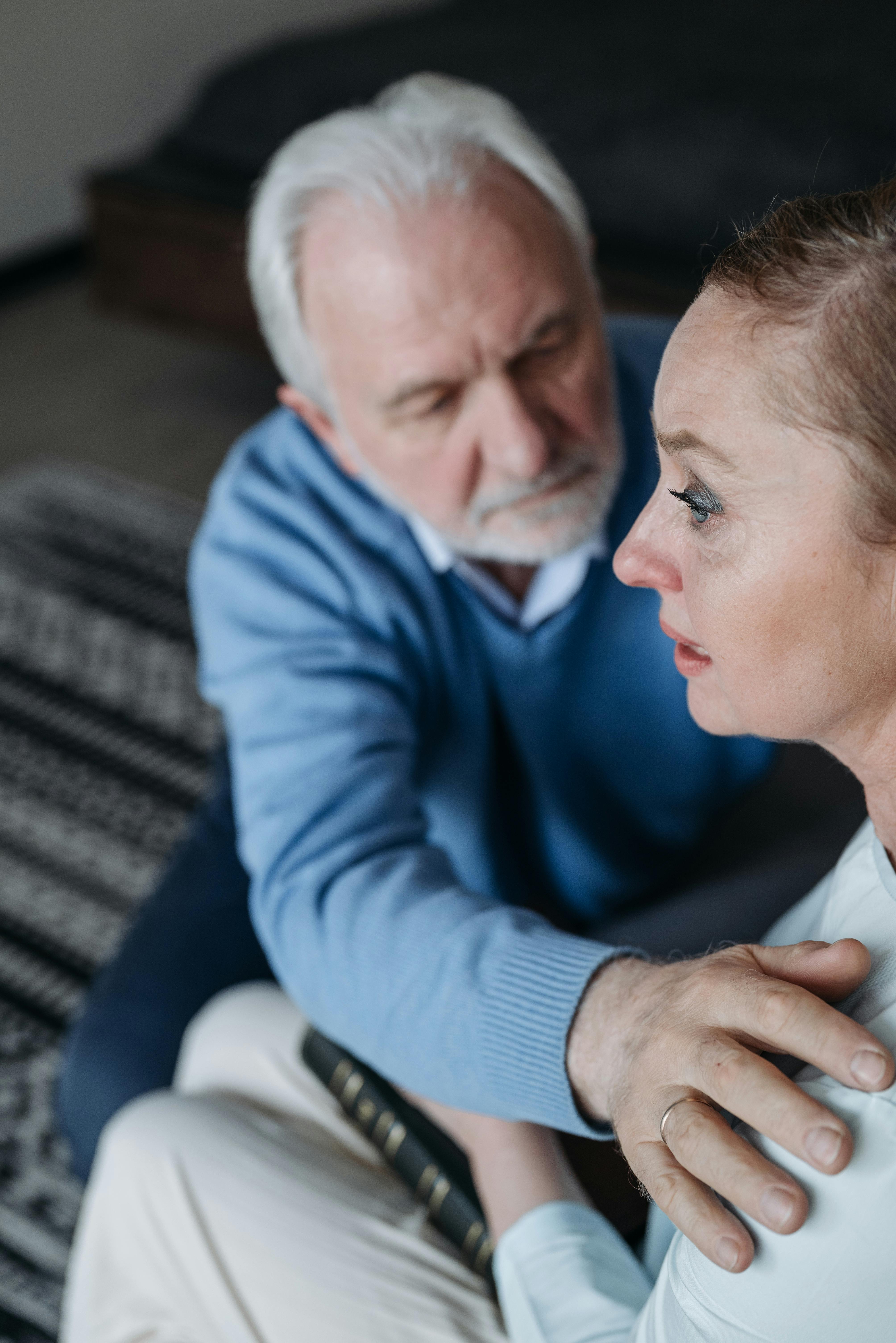 An upset elderly woman is comforted by her husband | Source: Pexels