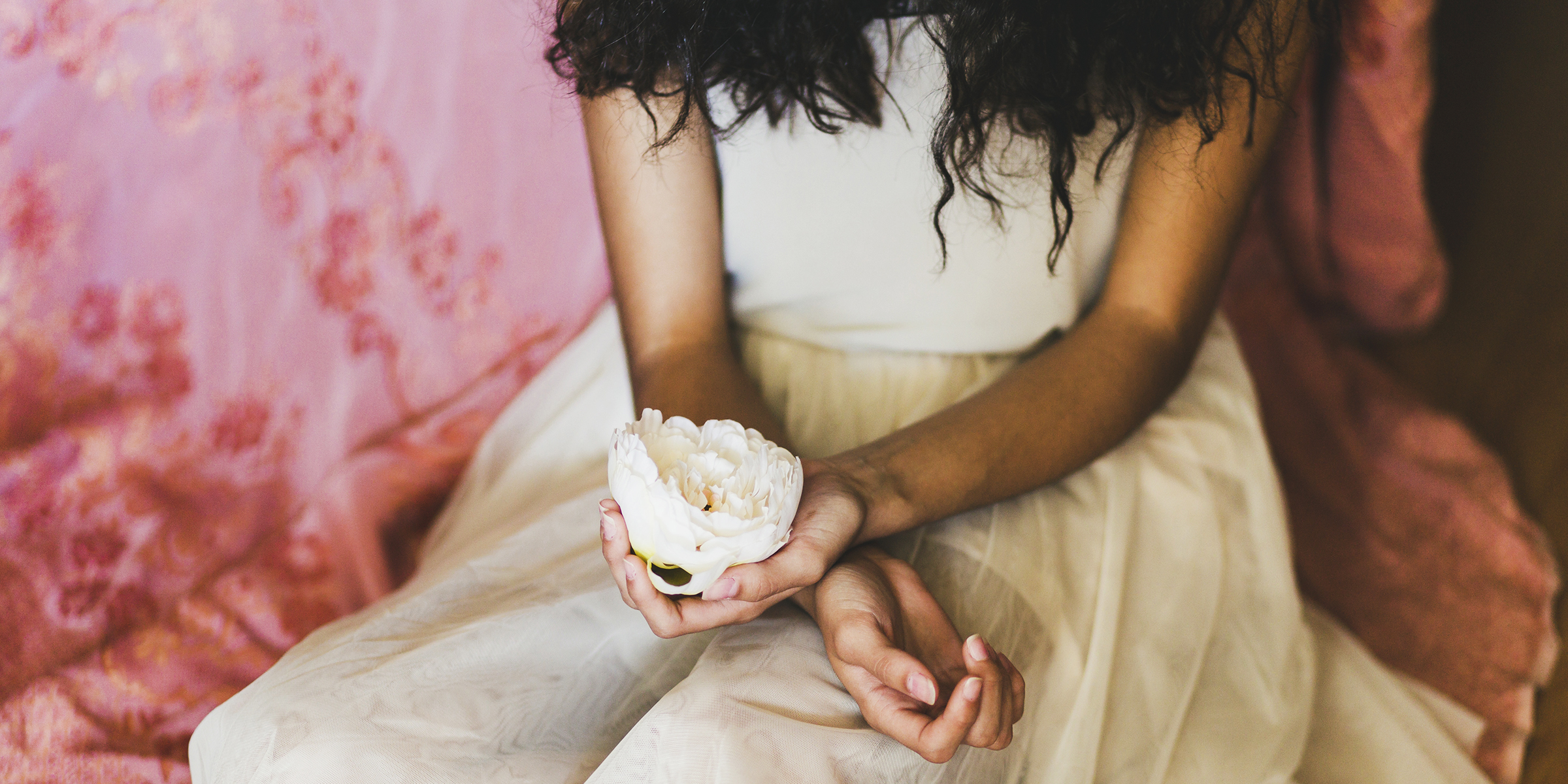 Photo recadrée d'une femme tenant une fleur | Source : Freepik