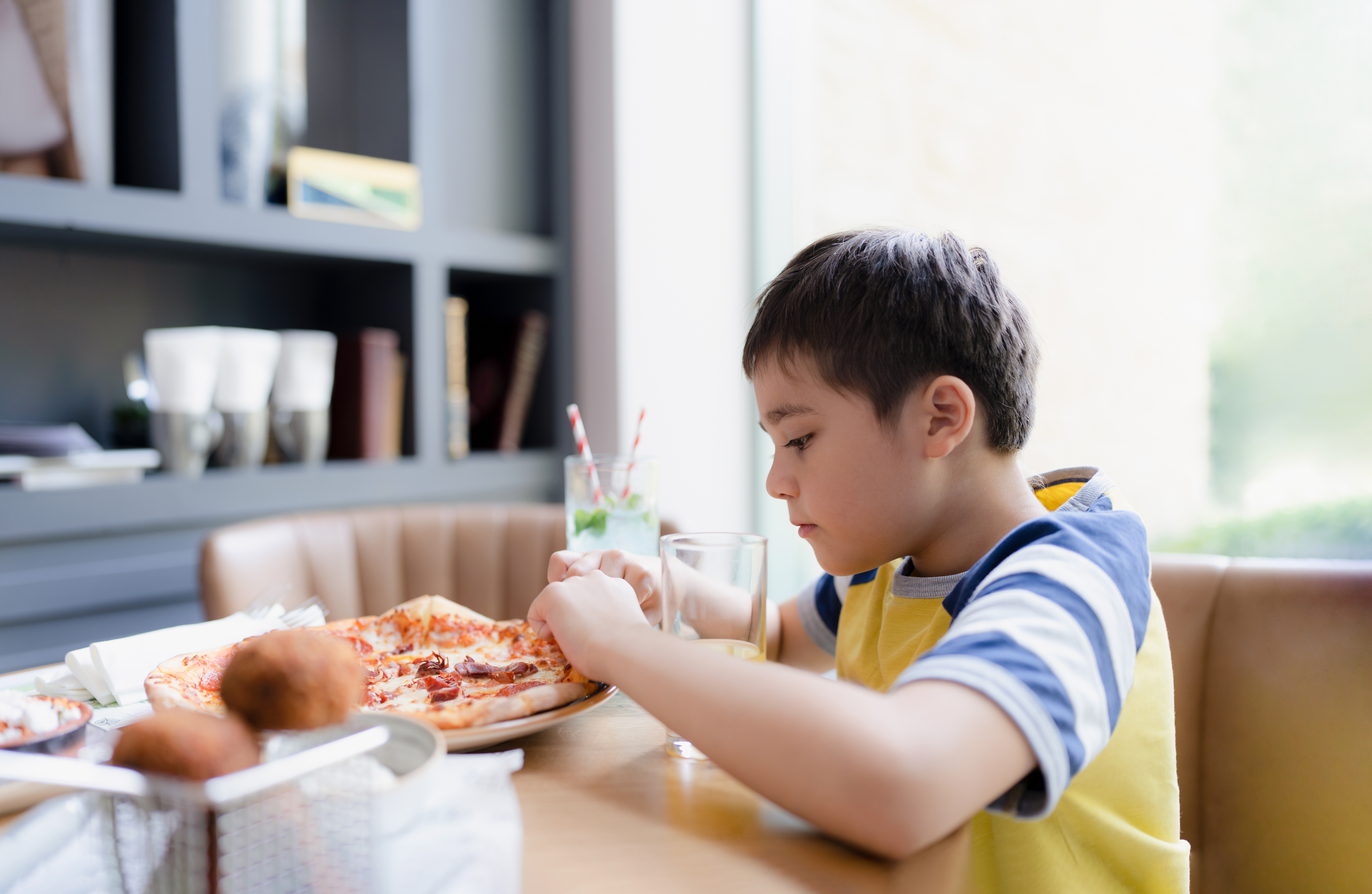 Garçon mangeant une pizza | Source : Shutterstock