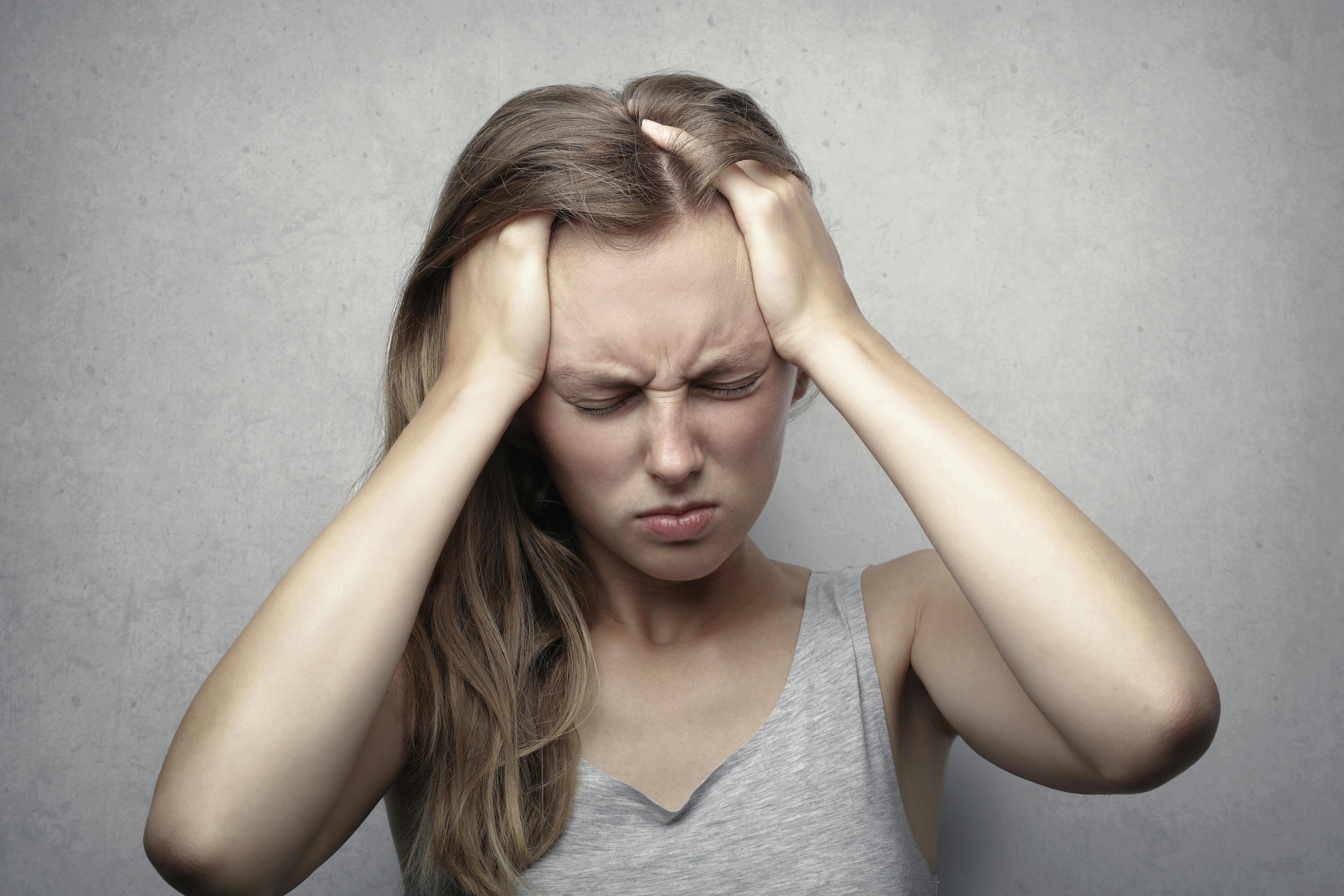 Une femme frustrée, les mains dans les cheveux et les yeux fermés | Source : Pexels