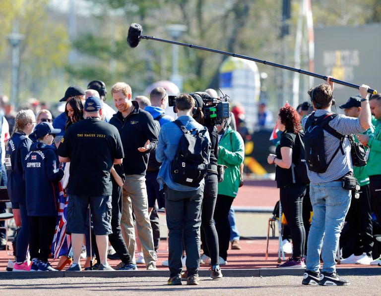 Meghan, duchesse de Sussex et le prince Harry, duc de Sussex (accompagnés d'une équipe de tournage) rencontrent des athlètes et leurs supporters lors de la compétition d'athlétisme le deuxième jour des Invictus Games 2020 au Zuiderpark, le 17 avril 2022 à La Haye, aux Pays-Bas. | Source : Getty Images