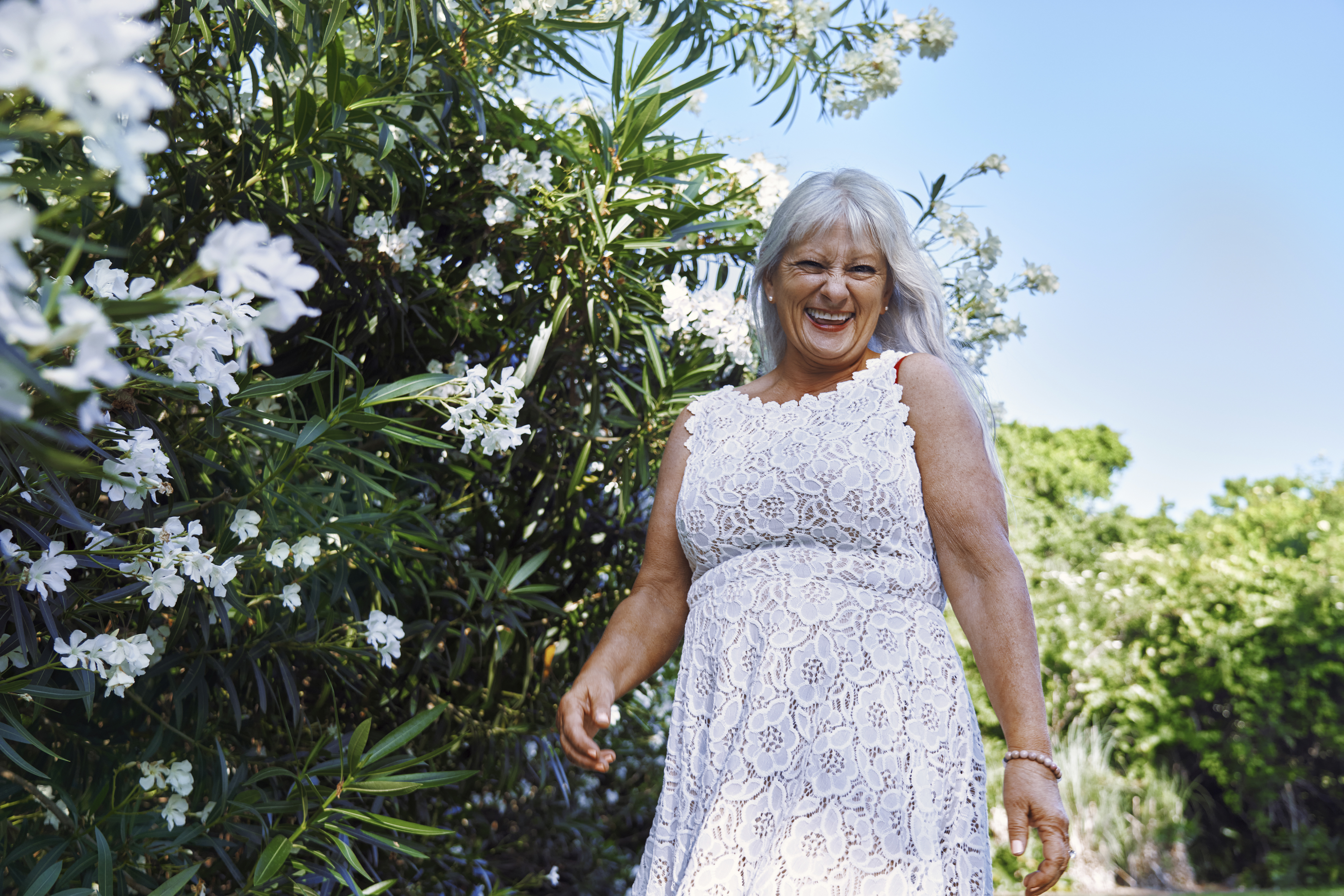 Une femme âgée heureuse dans une robe blanche | Source : Getty Images