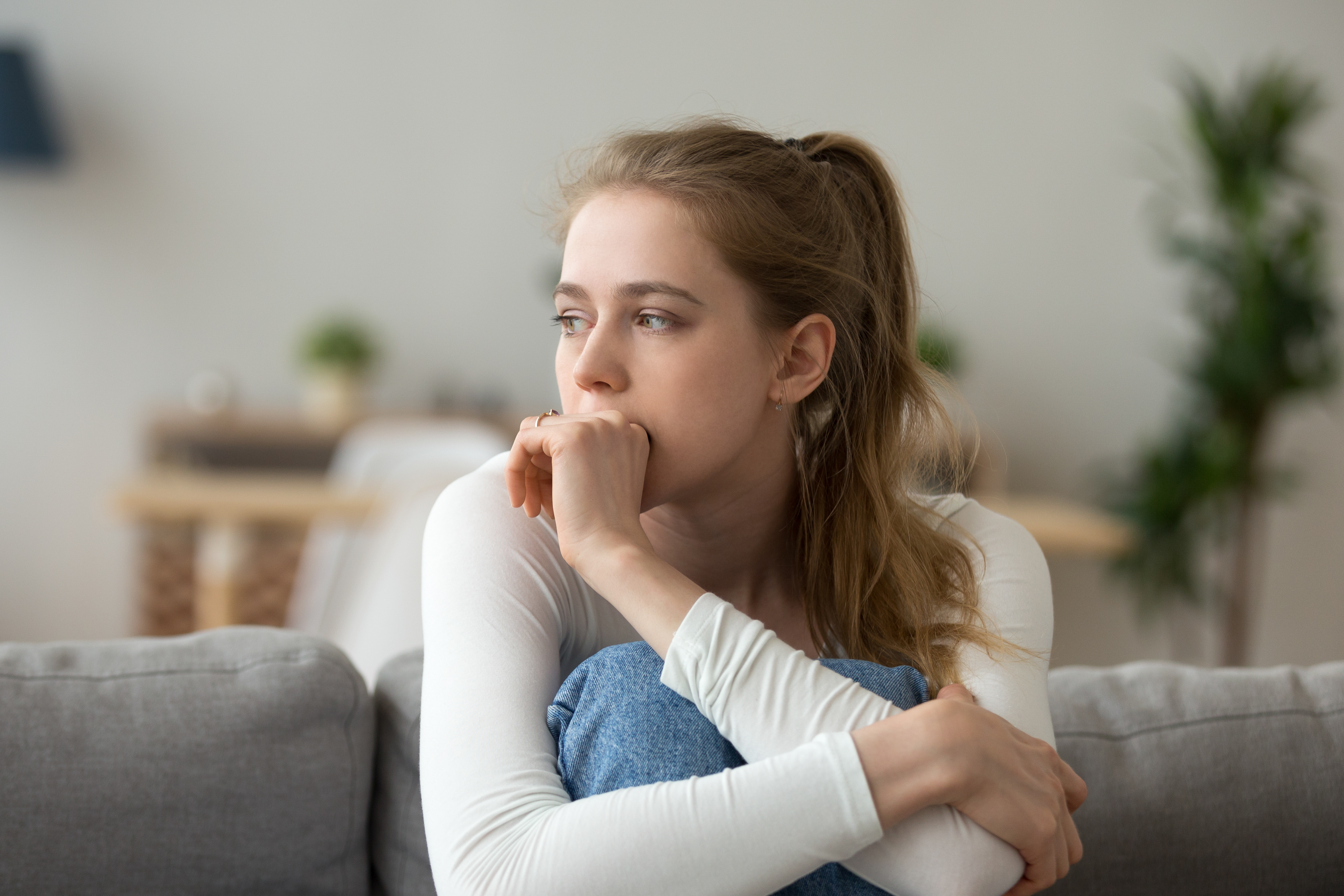 Uma jovem sentada em um sofá | Fonte: Shutterstock