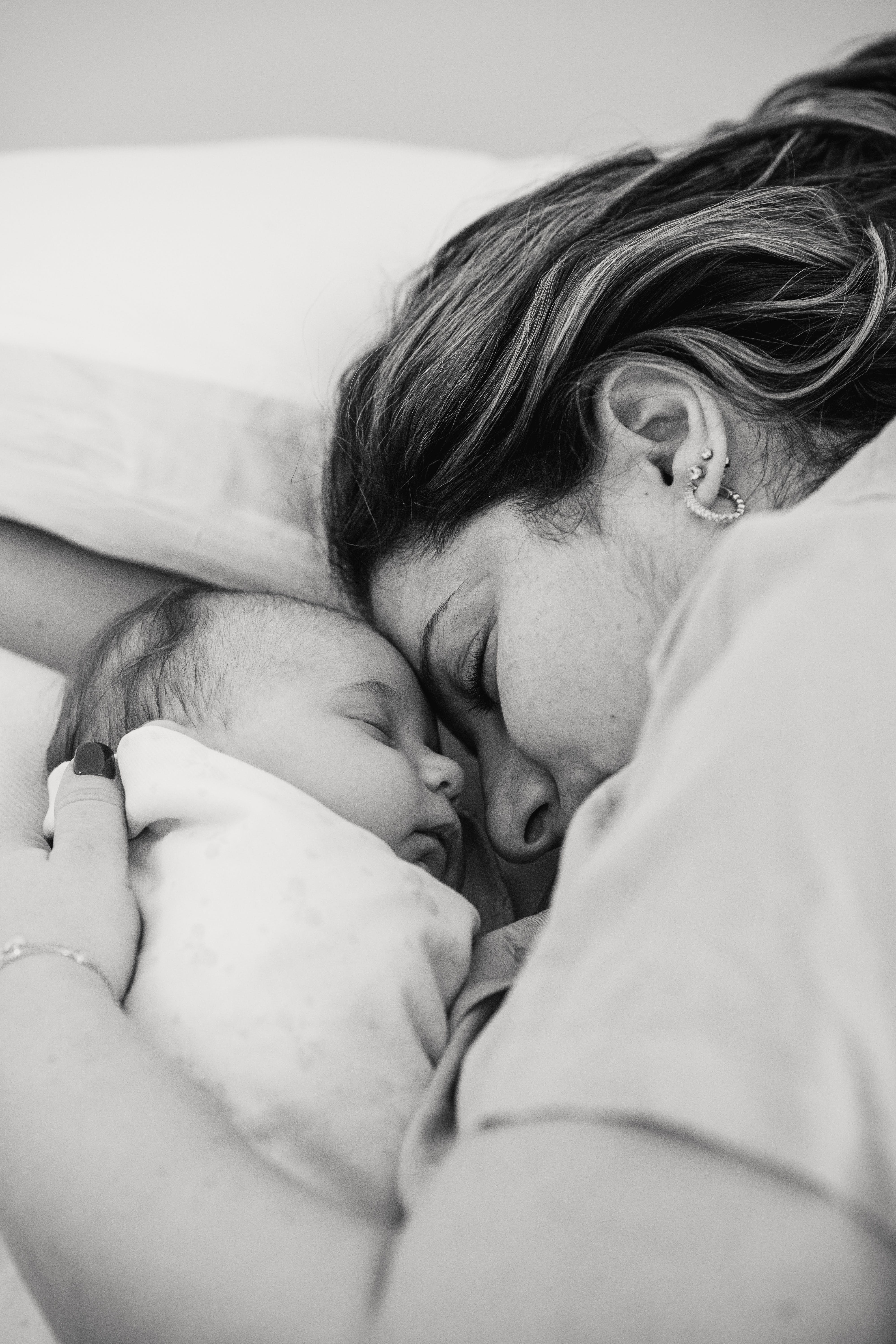 Une mère allongée avec son nouveau-né | Source : Pexels