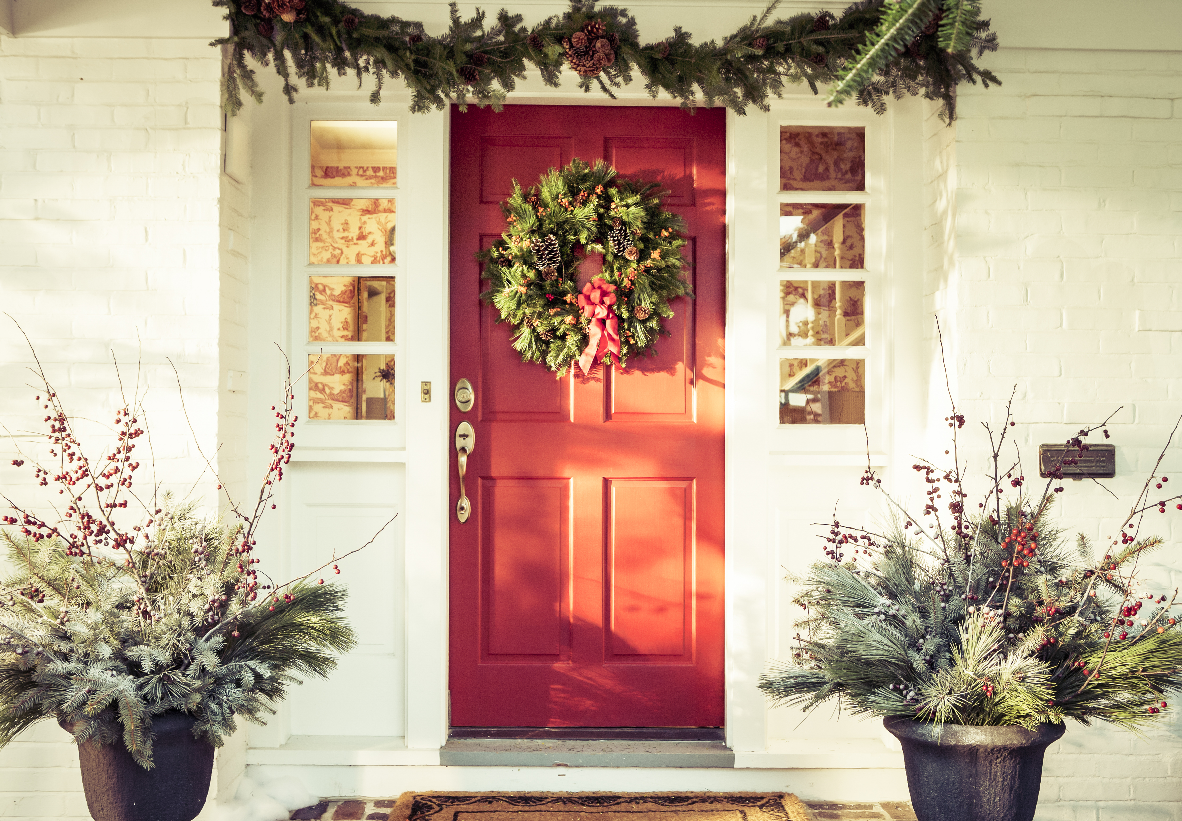 Une porte rouge décorée pour Noël | Source : Getty Images