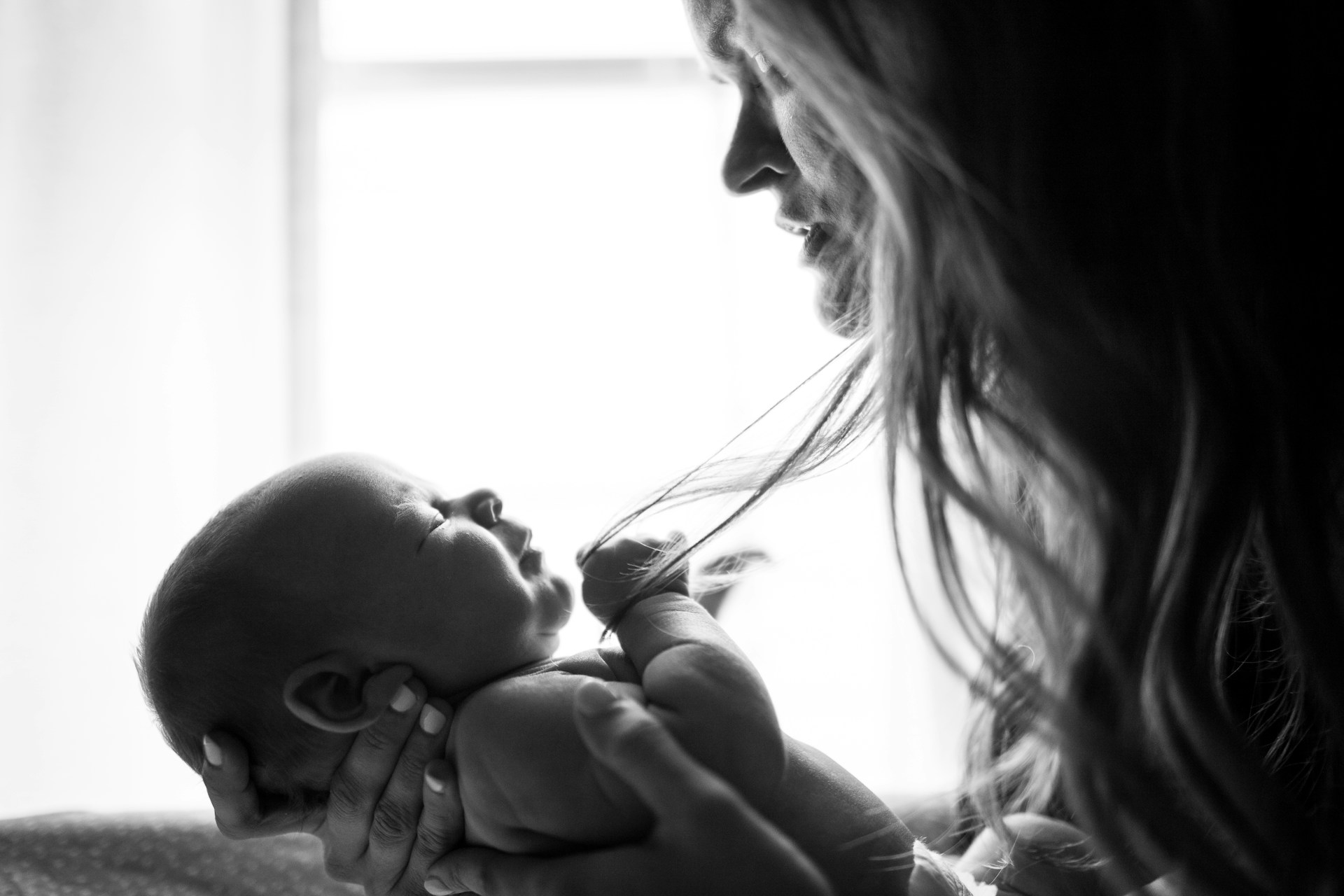 Une mère triste qui regarde son bébé | Source : Unsplash