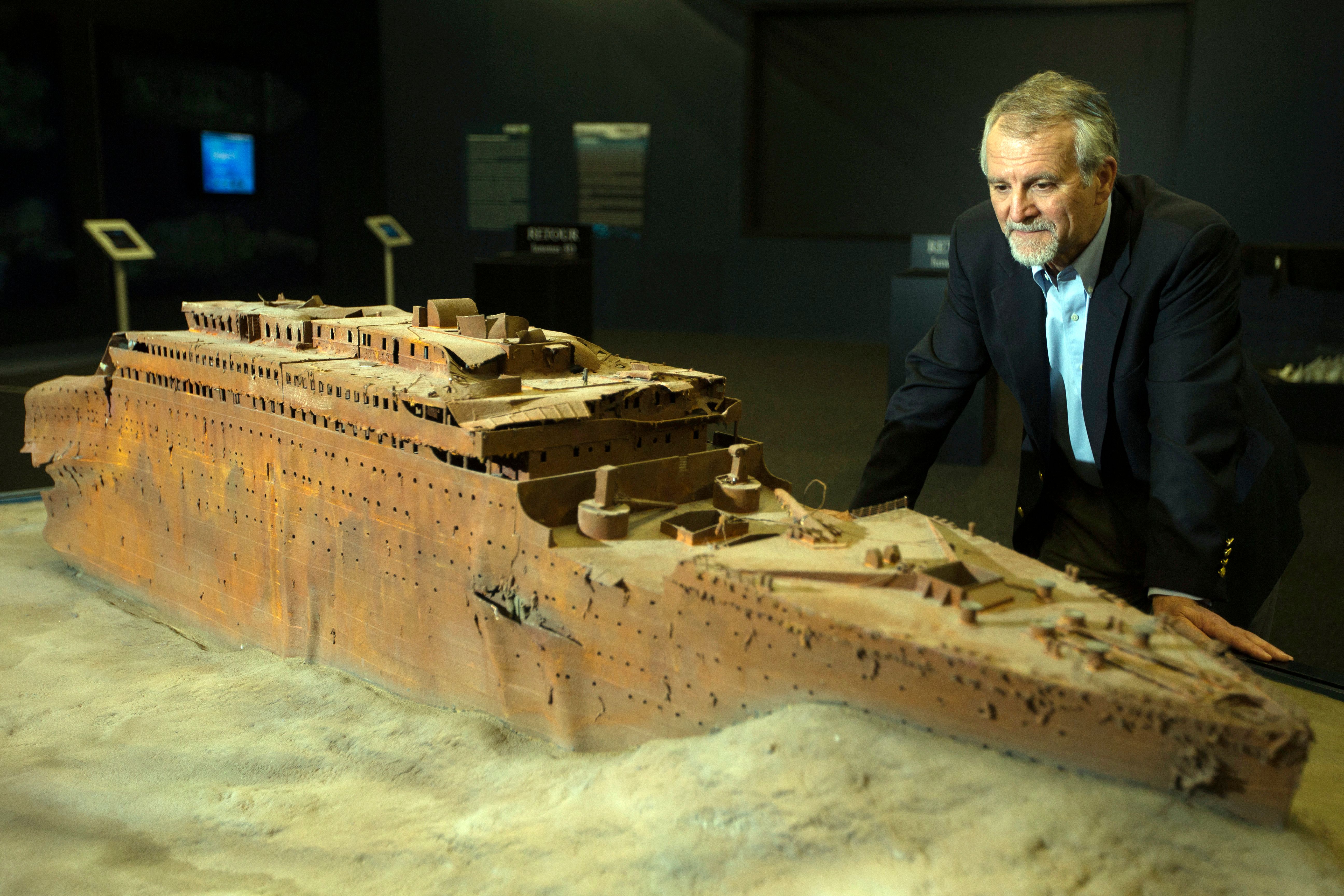 Paul-Henri Nargeolet avec une version miniature du navire coulé à l'intérieur d'une nouvelle exposition, à 'Paris Expo', le 31 mai 2013, à Paris | Source : Getty Images