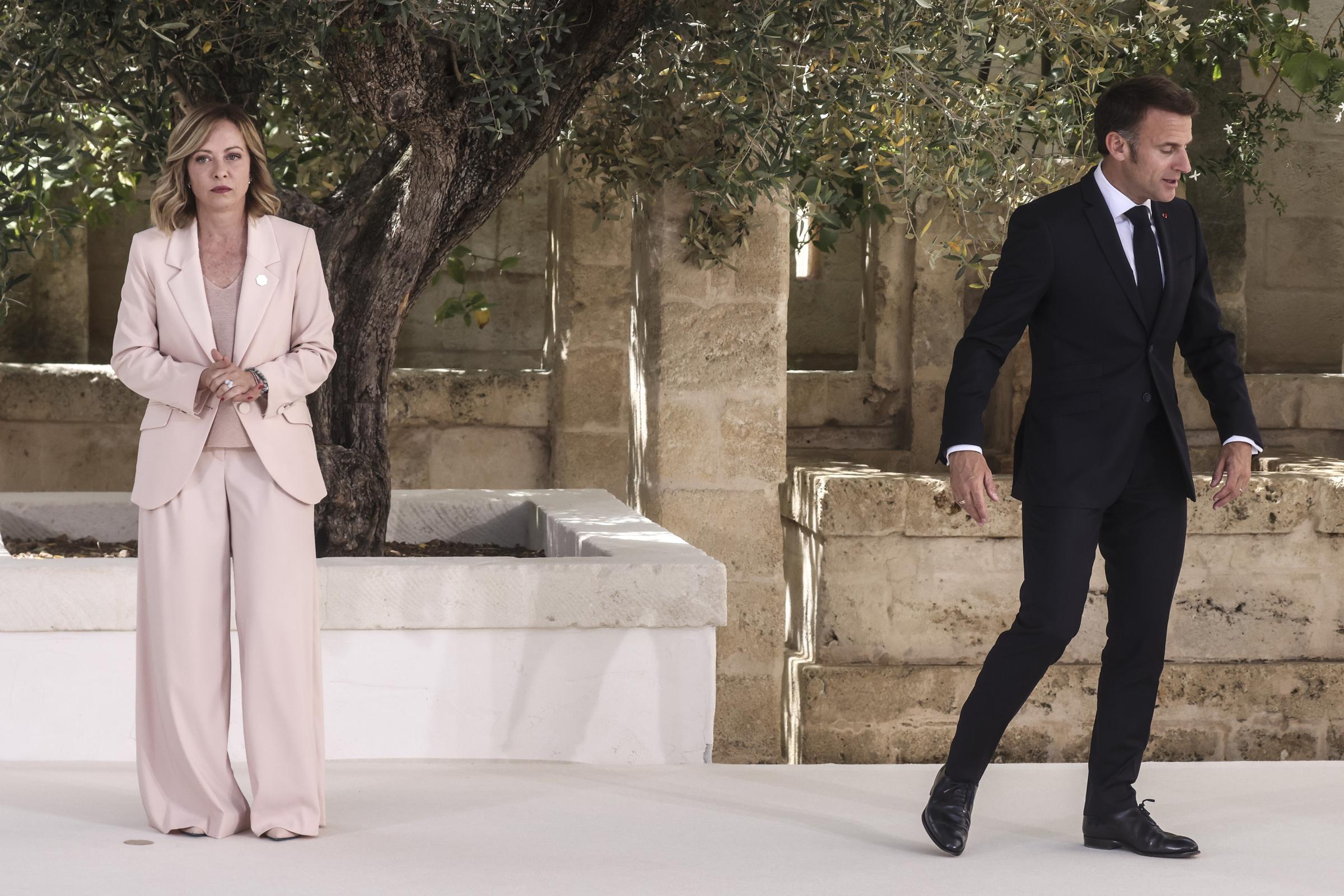 Emmanuel Macron s'éloigne de Giorgia Meloni au centre de villégiature Borgo Egnazia, où elle attend debout, les mains jointes.