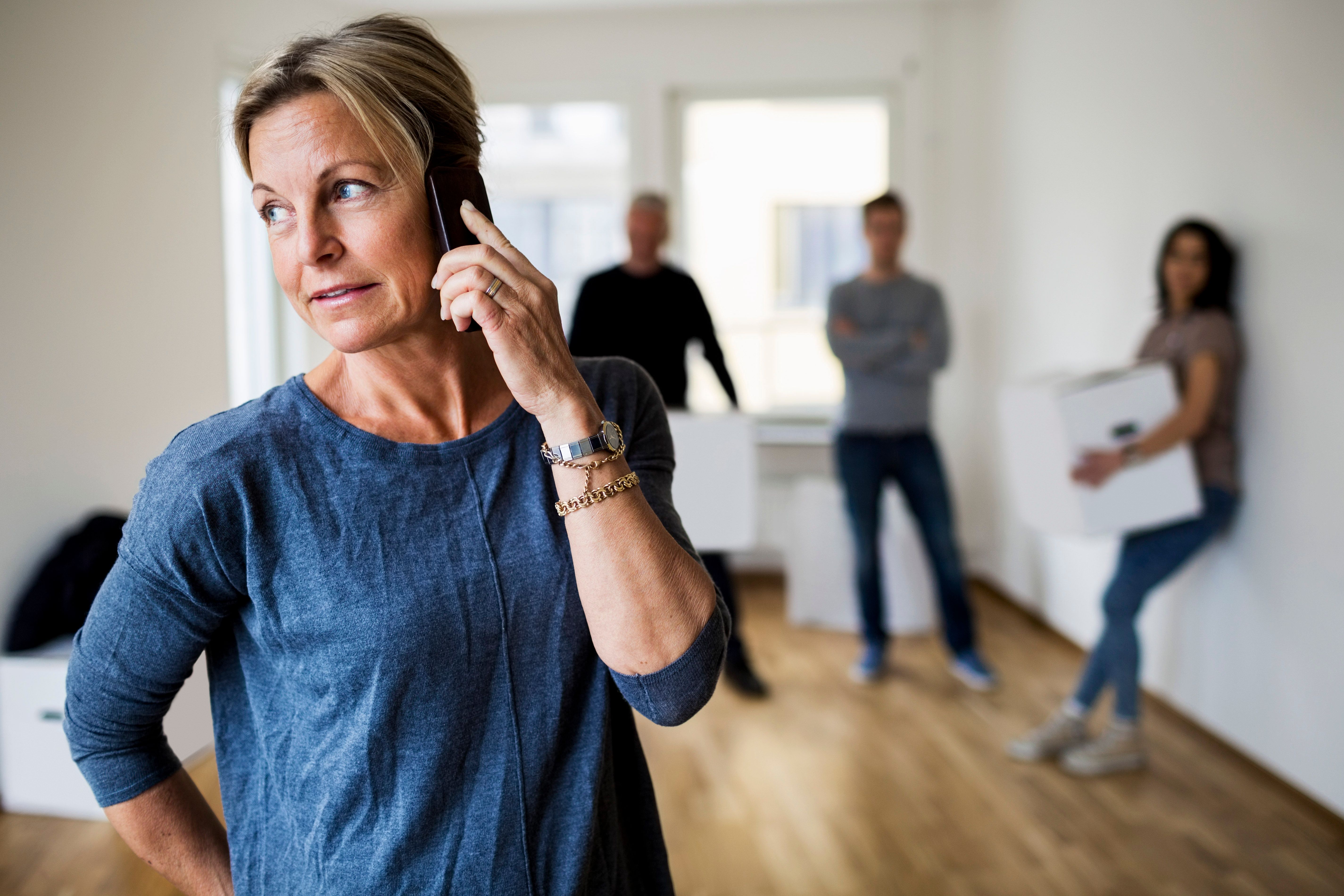 Une femme qui parle au téléphone alors que des gens sont derrière elle. | Source : Getty Images