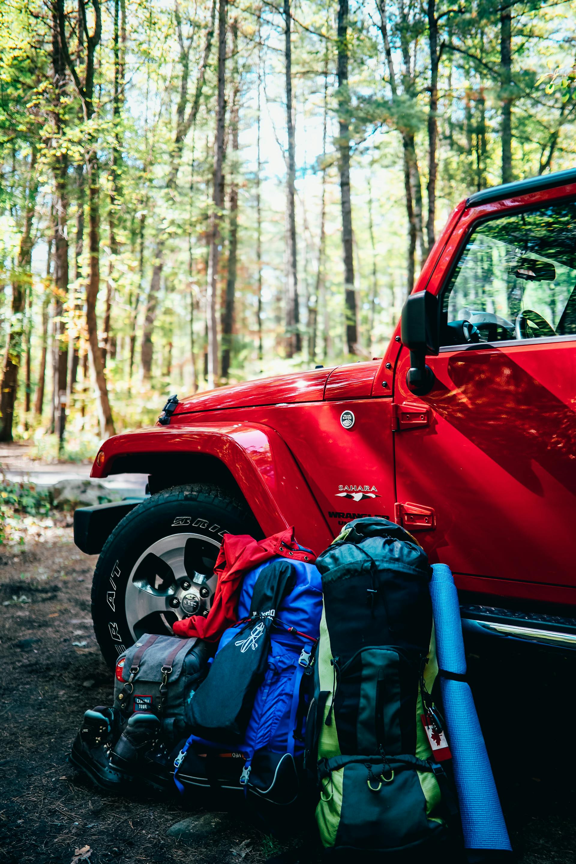 Sacs à dos et matériel de camping adossés à une voiture | Source : Pexels