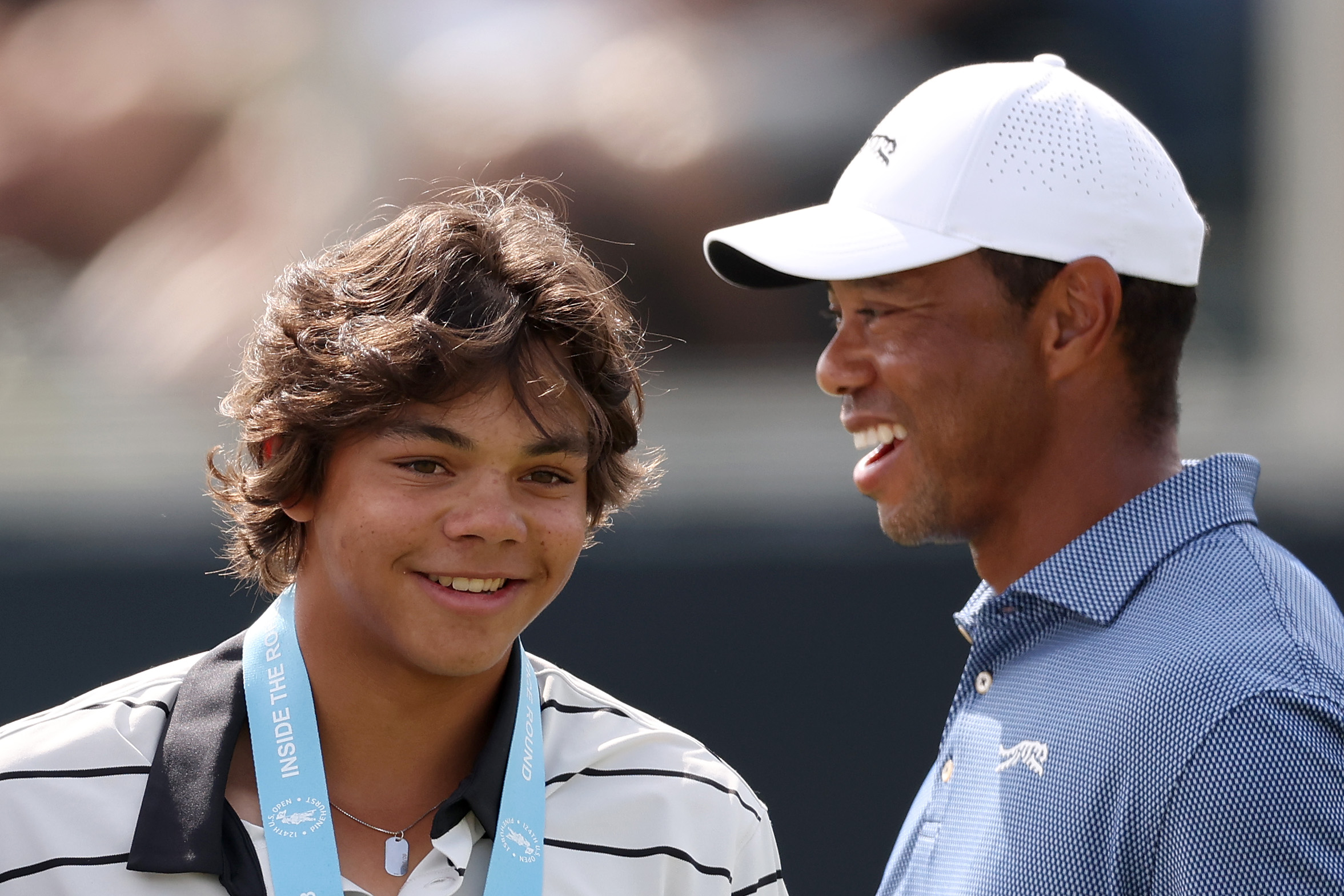 Charlie Woods et Tiger Woods sourient pendant un tour d'entraînement avant l'U.S. Open à Pinehurst Resort en Caroline du Nord, le 10 juin 2024. | Source : Getty Images